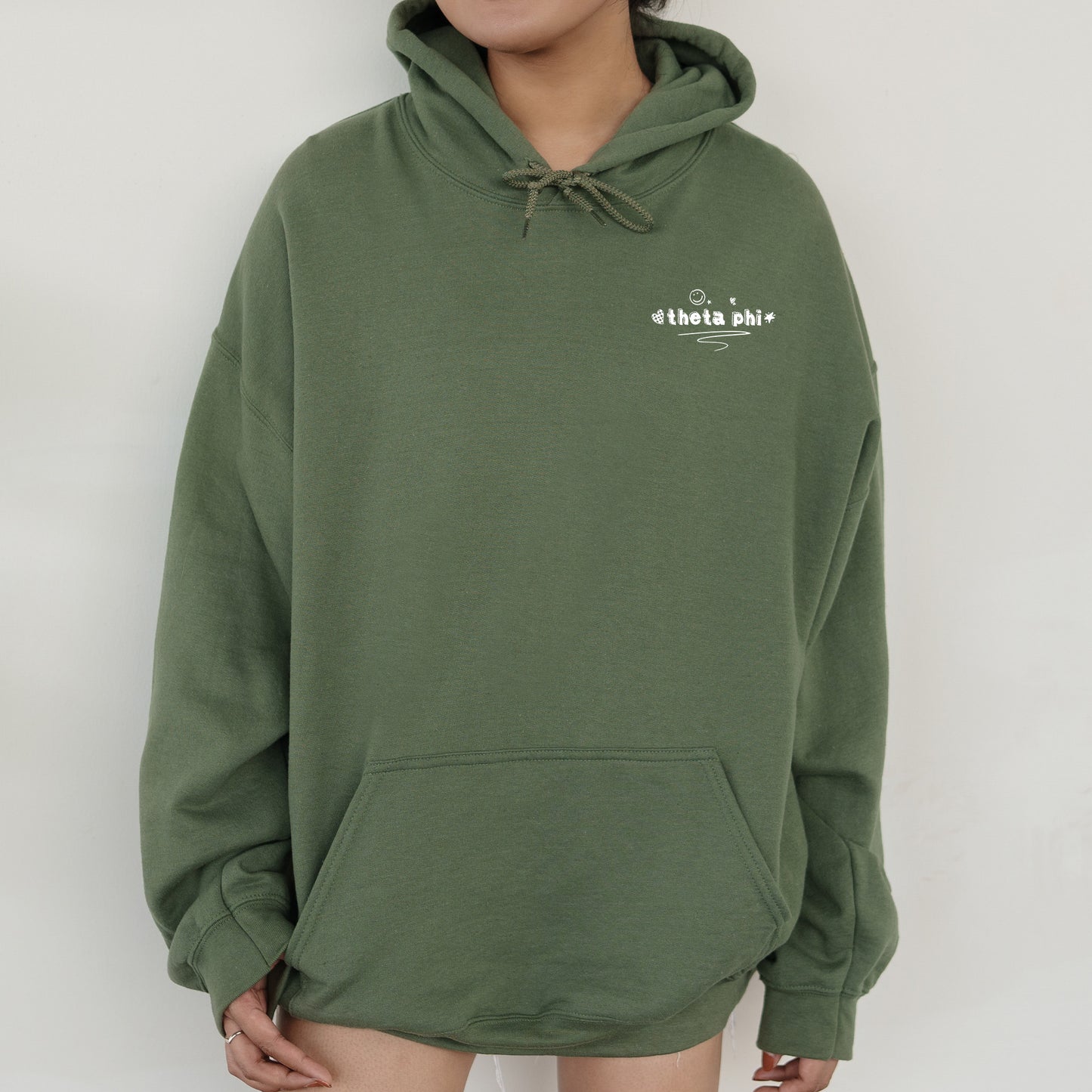 a person wearing a green hoodie with a white logo on it