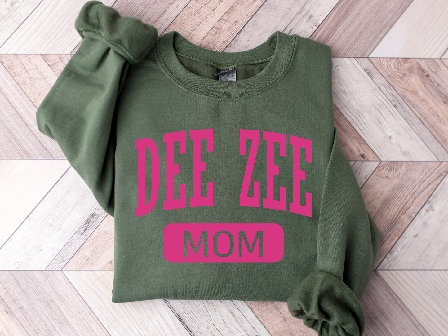 a green sweatshirt with pink lettering that says dee zeee mom