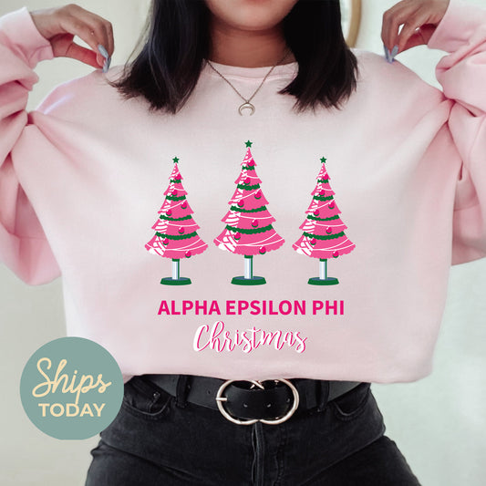 a woman wearing a pink sweatshirt with christmas trees on it