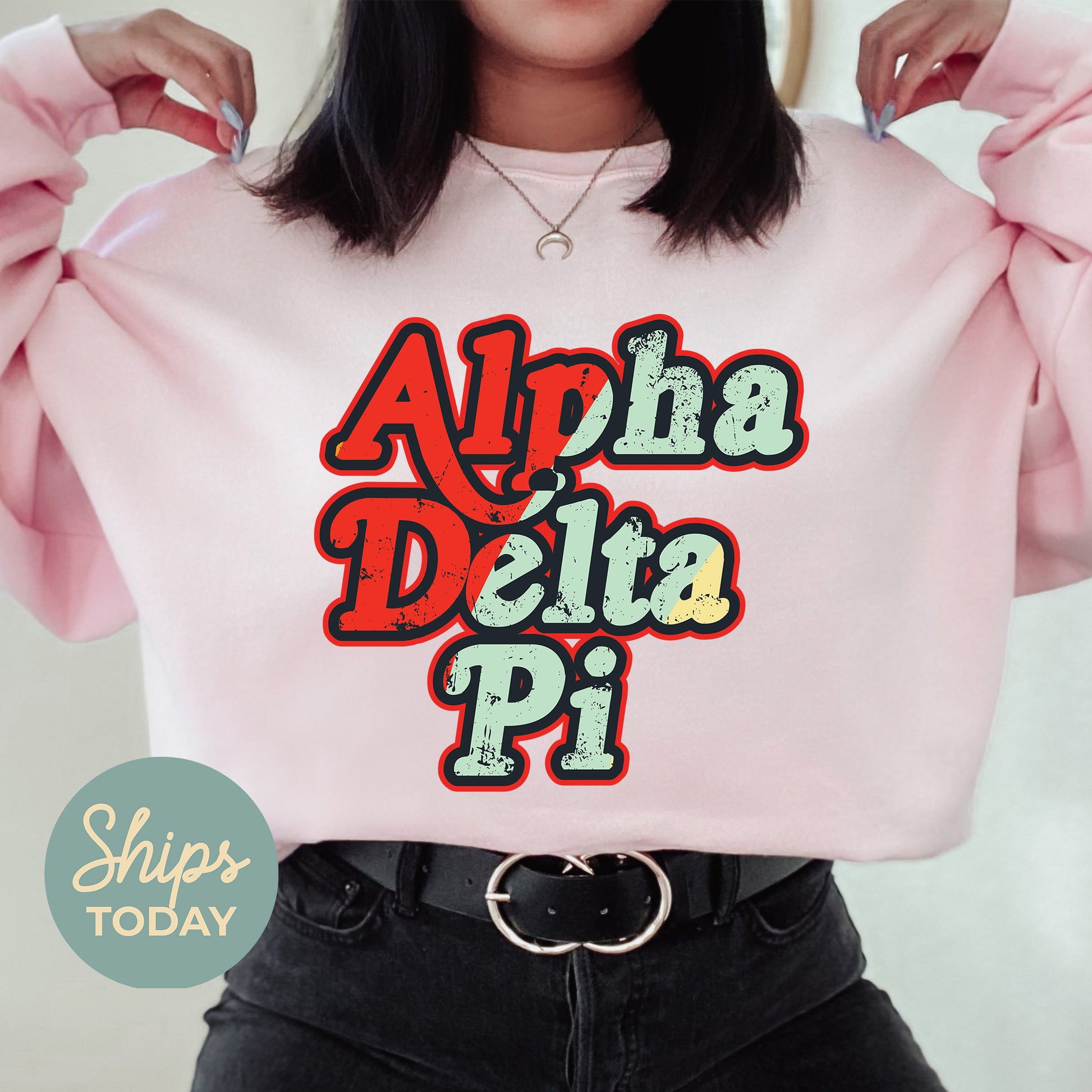 a woman wearing a pink sweatshirt with the words aha delta pi on it