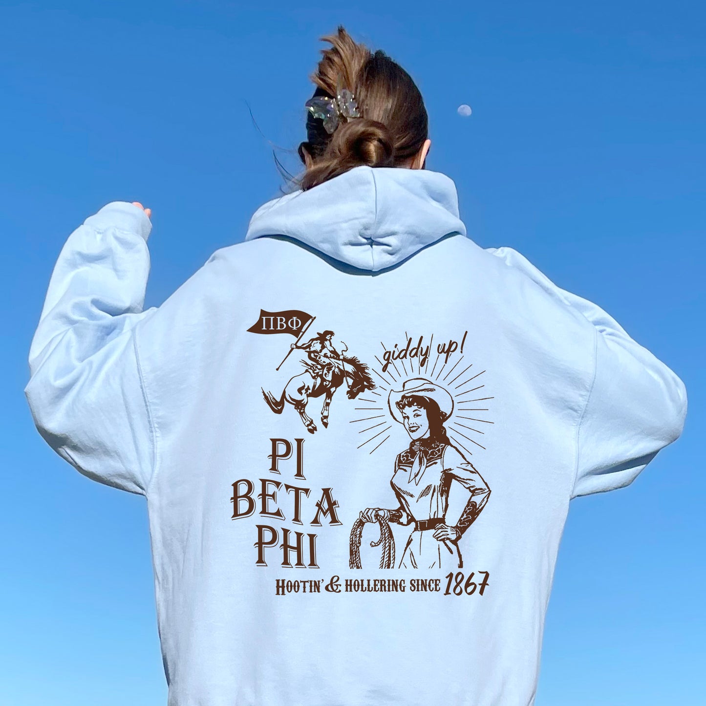 a woman in a white hoodie is flying a kite