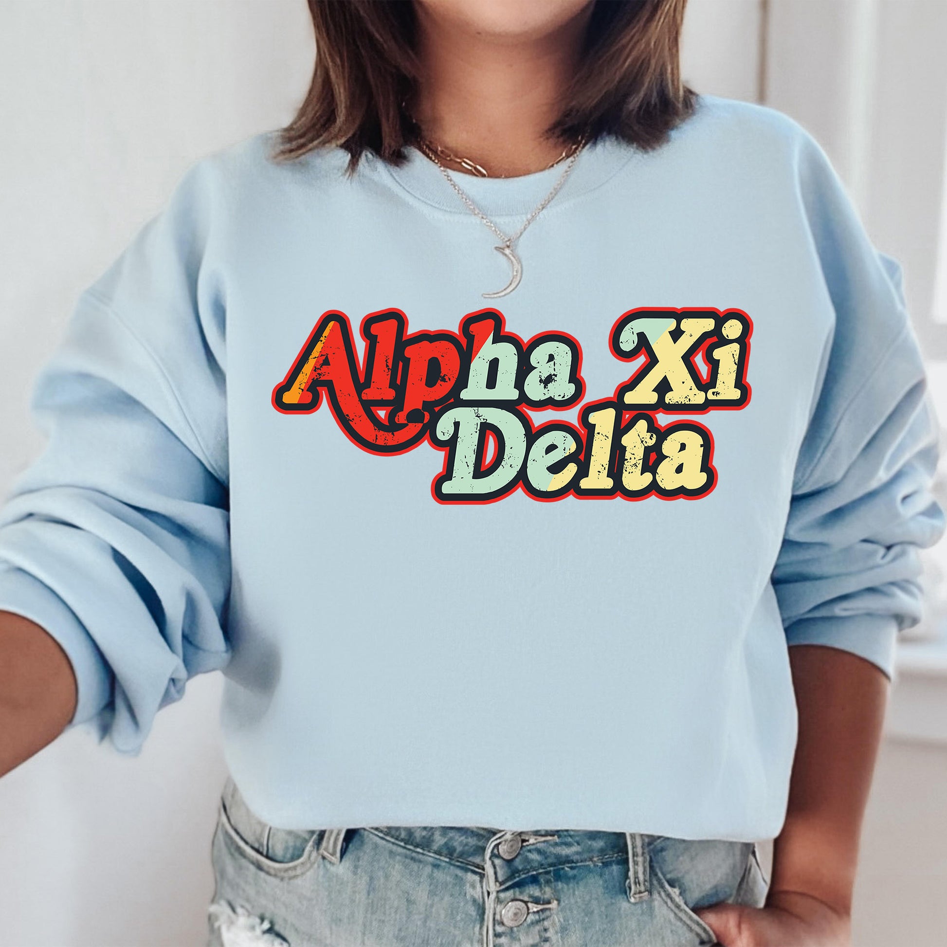 a woman wearing a blue sweatshirt with the word apa xi delta printed on it