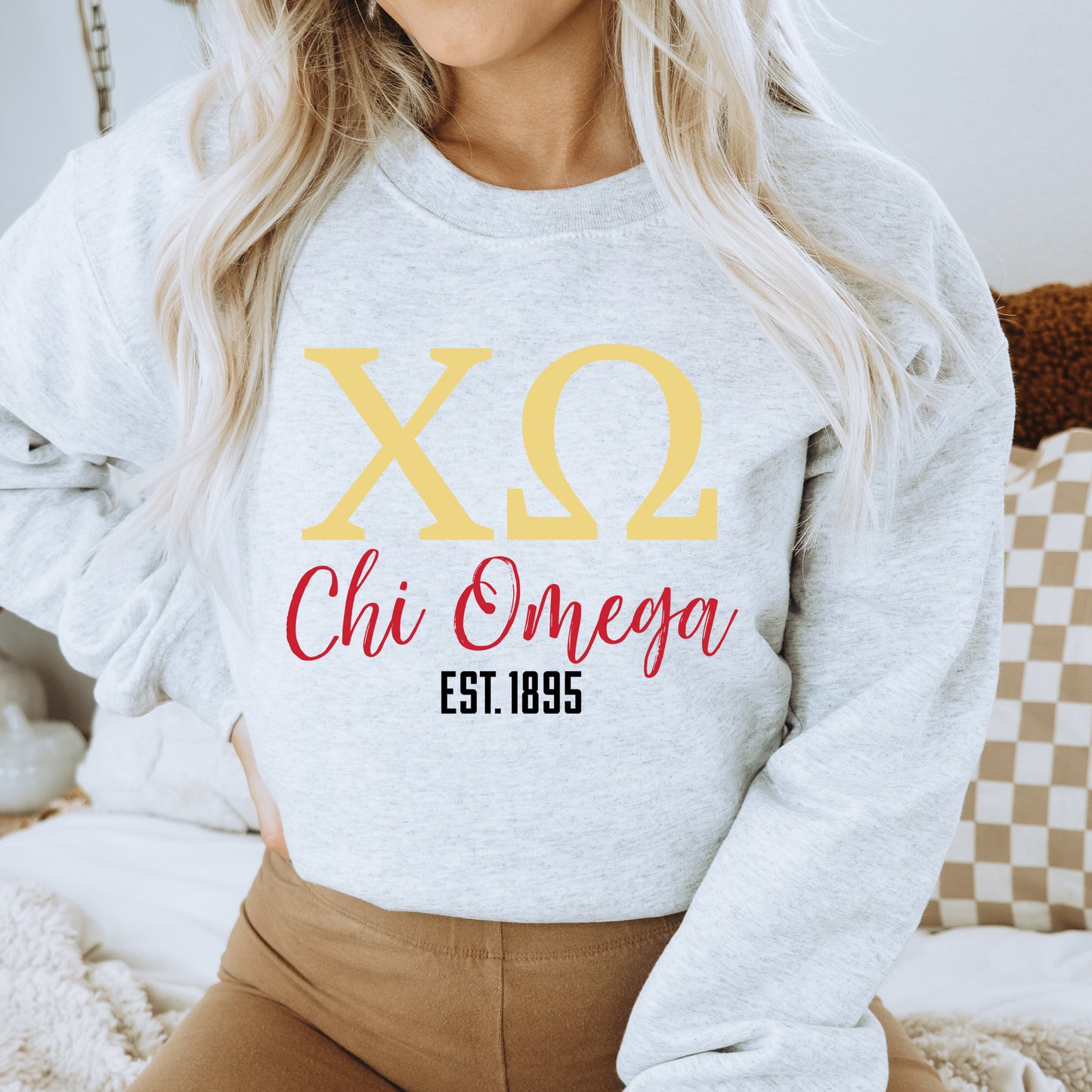 a woman wearing a sweatshirt that says chi omega est 1965