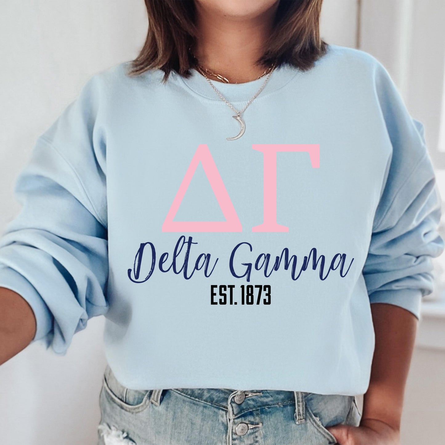 a woman wearing a light blue delta garma sweatshirt