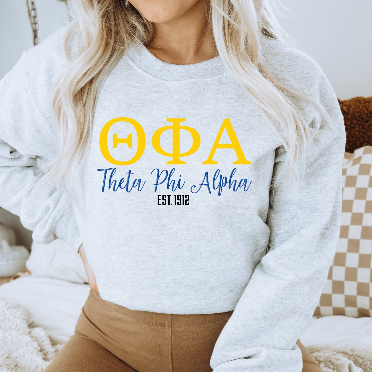 a woman wearing a sweatshirt with the greek alphabet on it