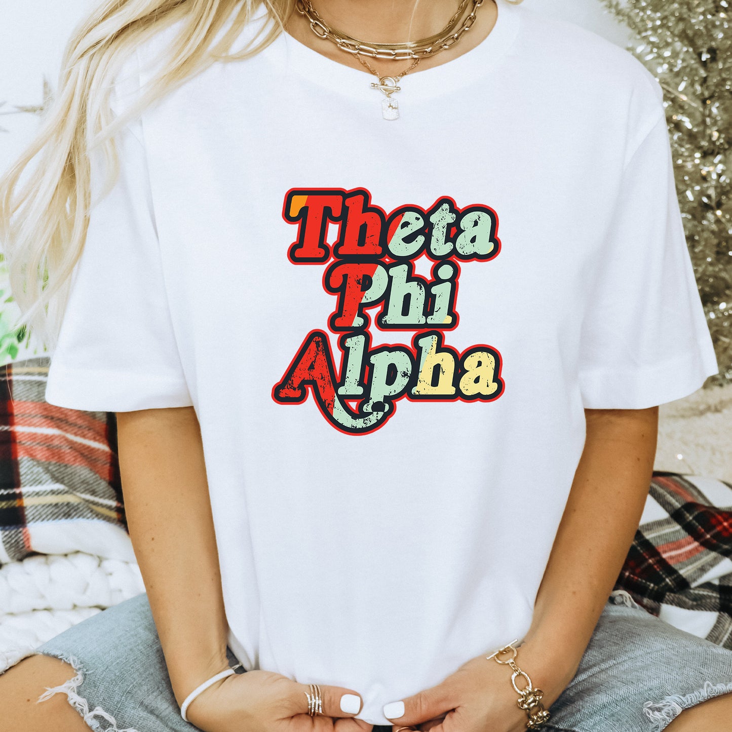 a woman wearing a white t - shirt that says thea phi aloha