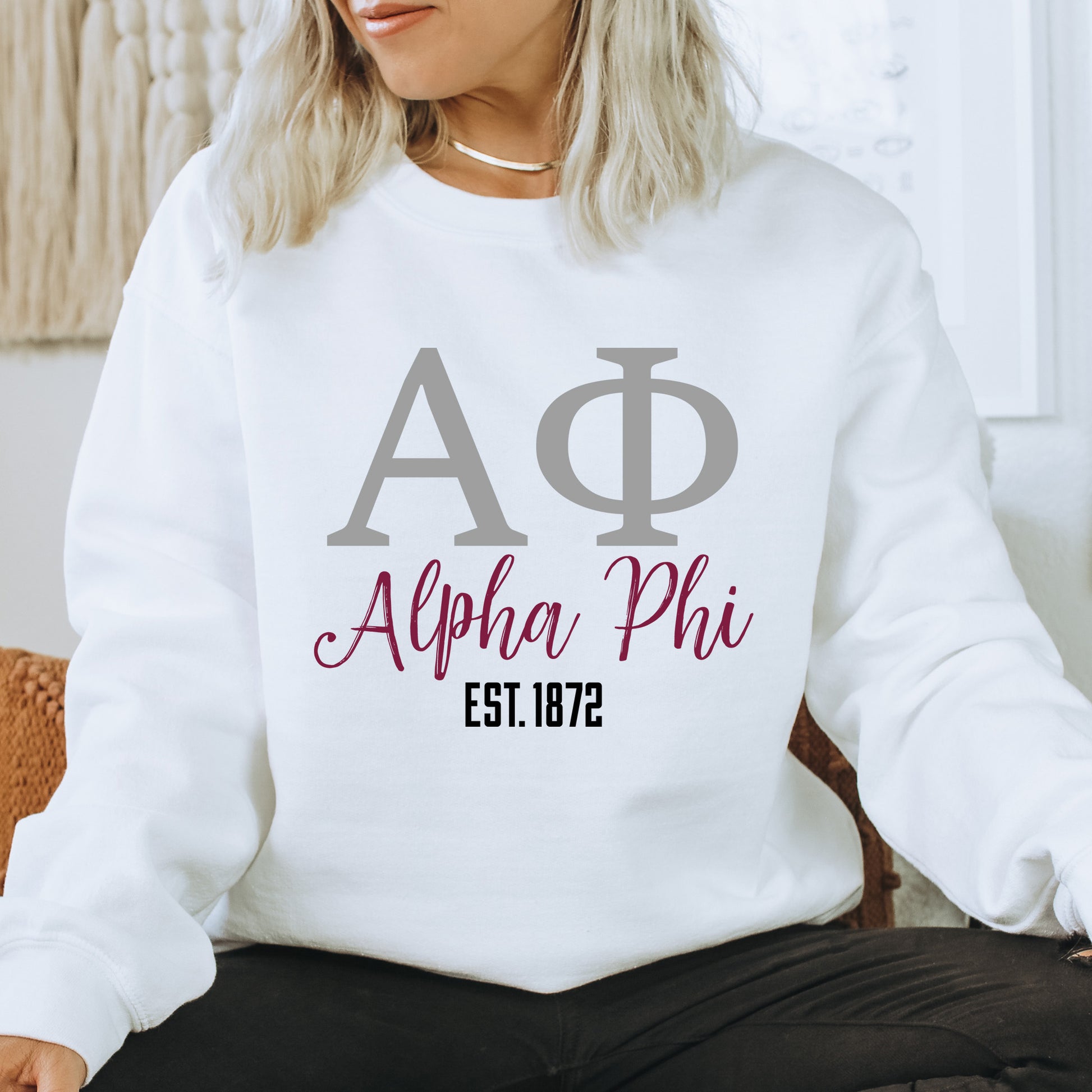 a woman sitting on a chair wearing a white sweatshirt