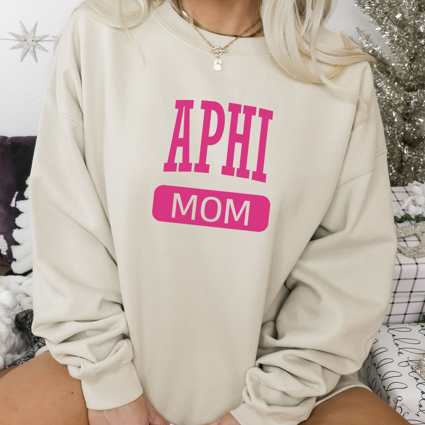 a woman wearing a sweatshirt that says aphi mom