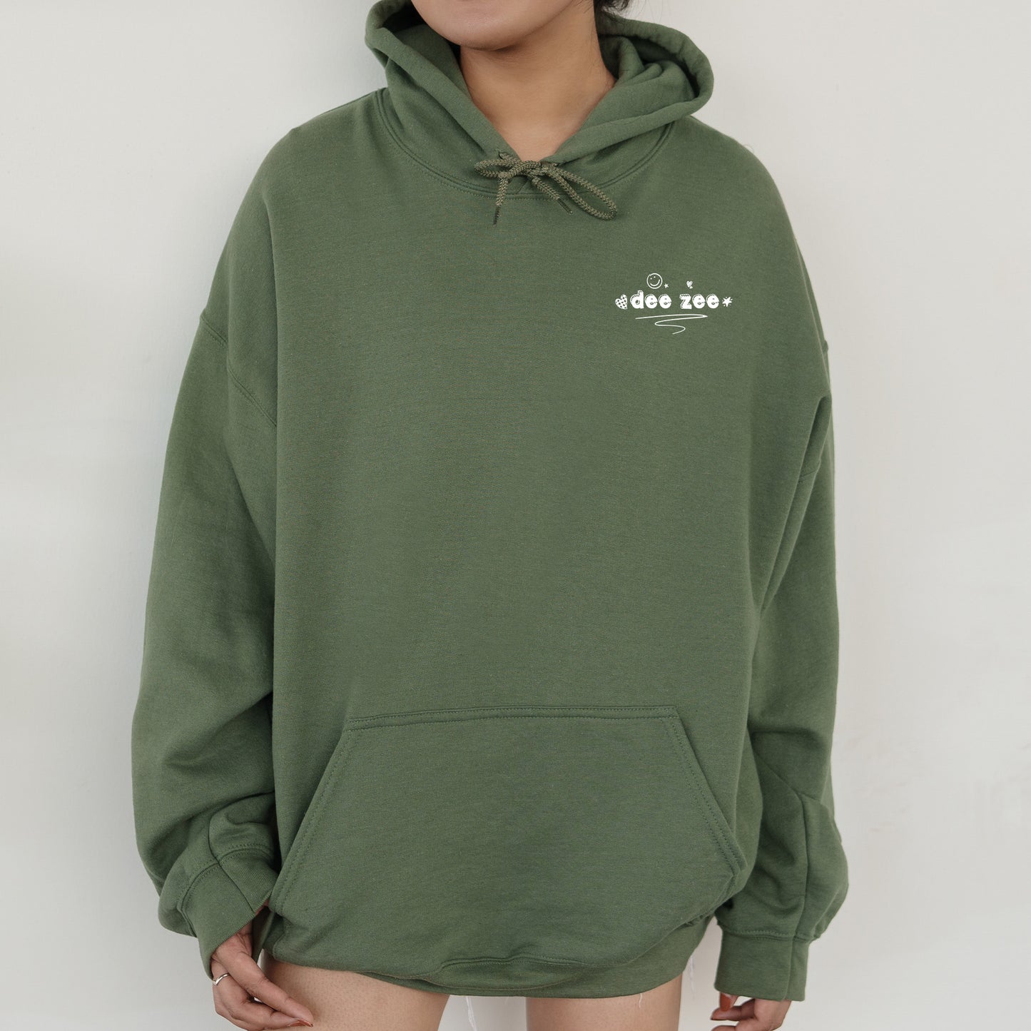 a person wearing a green hoodie with a white logo on it