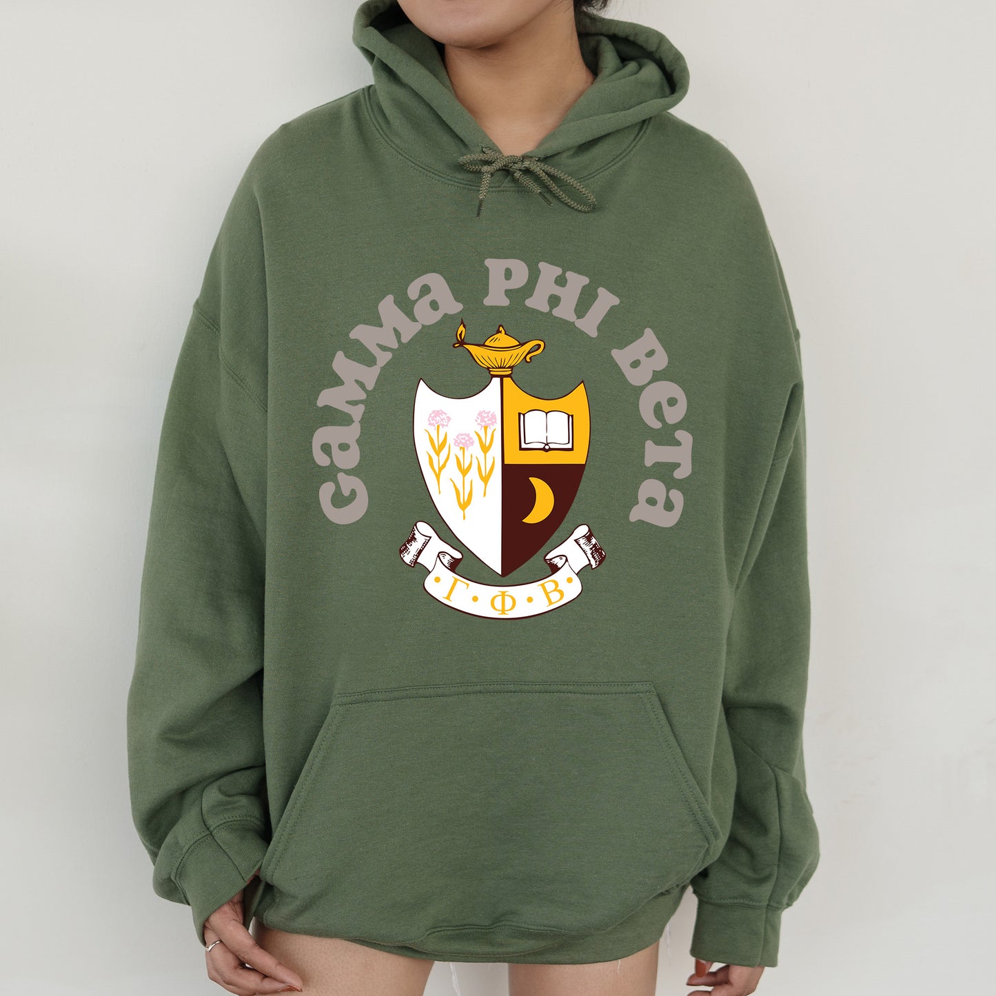 a person wearing a green hoodie with a crest on it