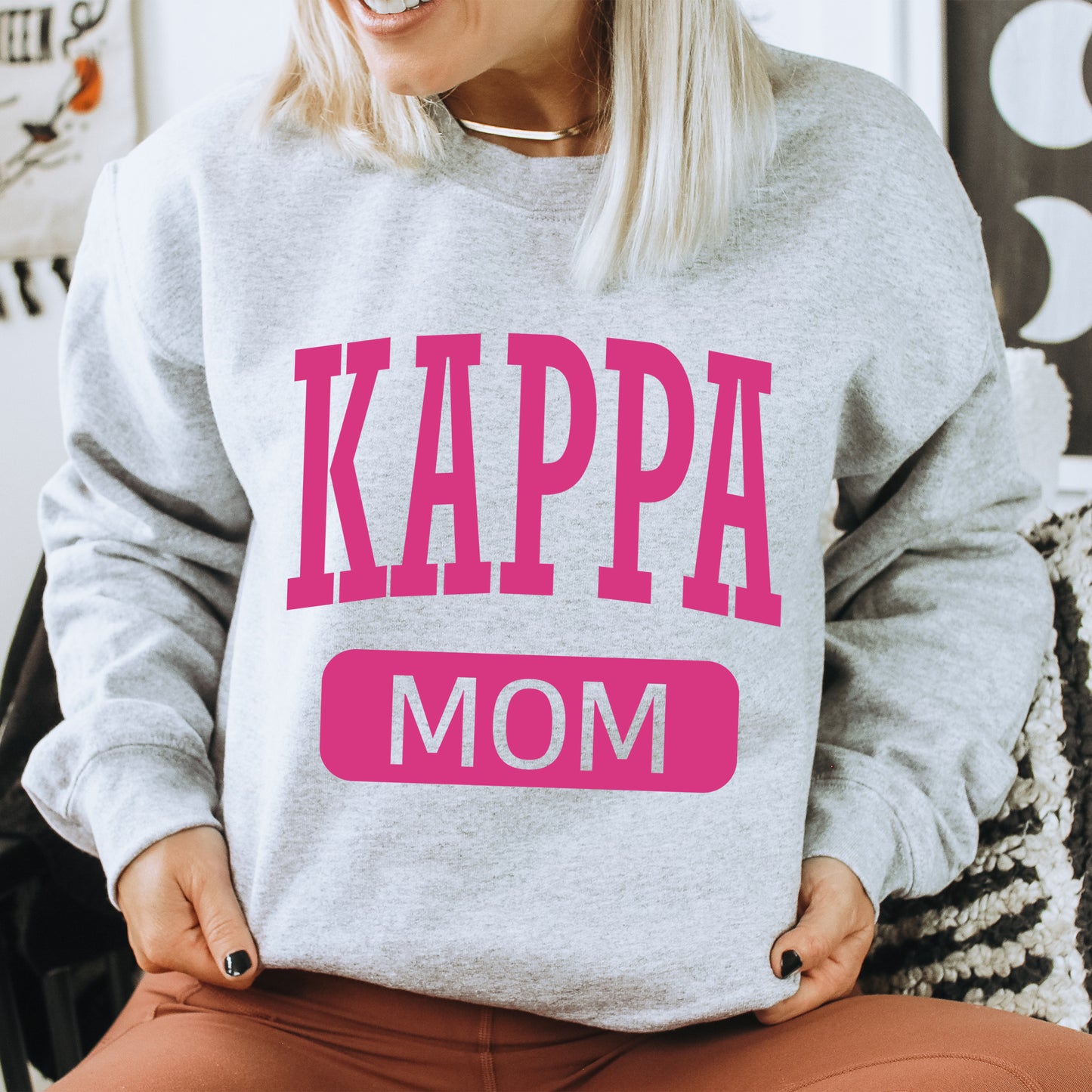 a woman wearing a sweatshirt that says kappa mom
