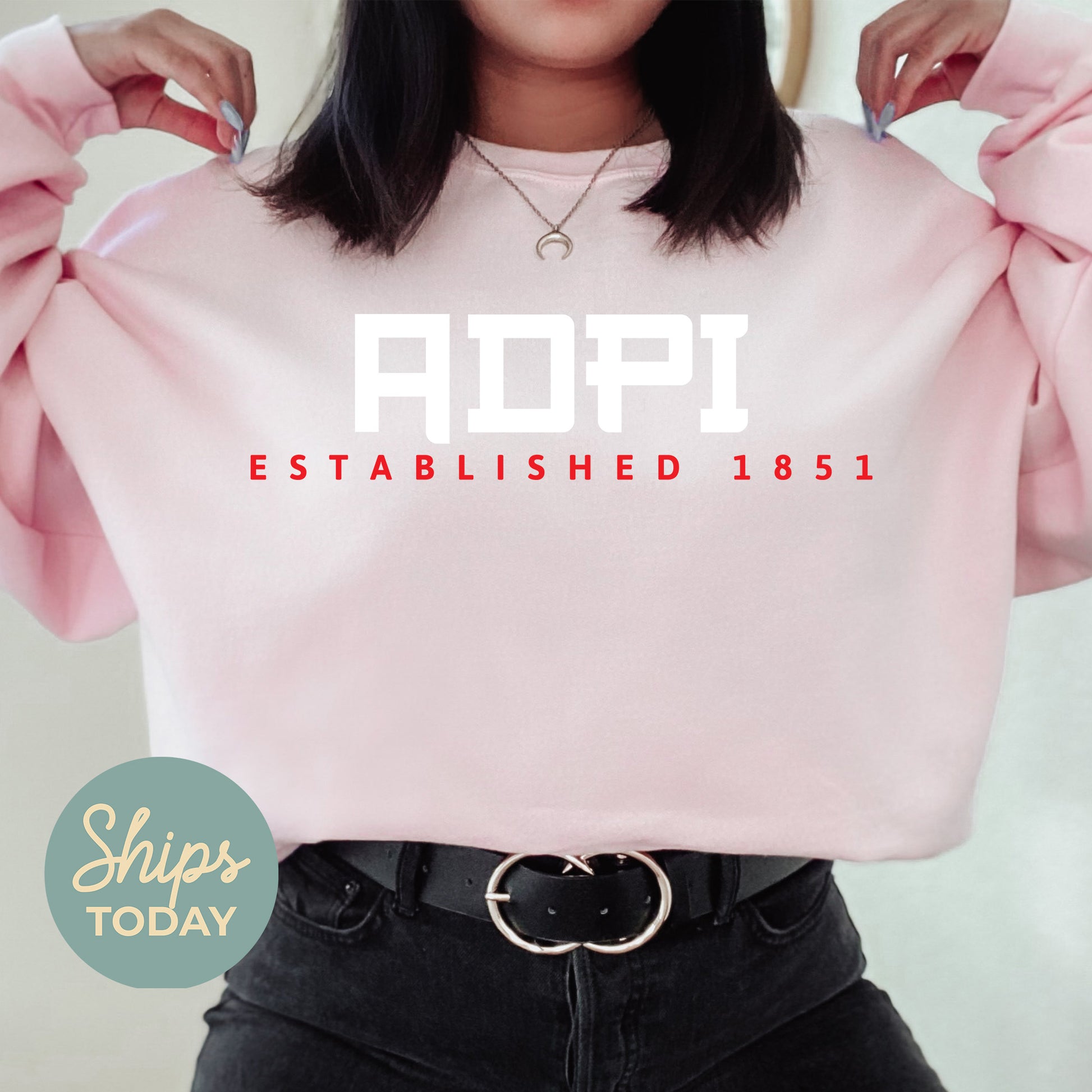 a woman wearing a pink sweatshirt with the words adopt established on it
