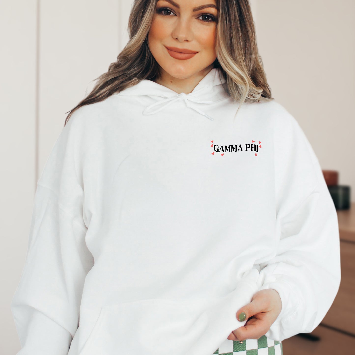 a woman wearing a white hoodie with a checkered bottom