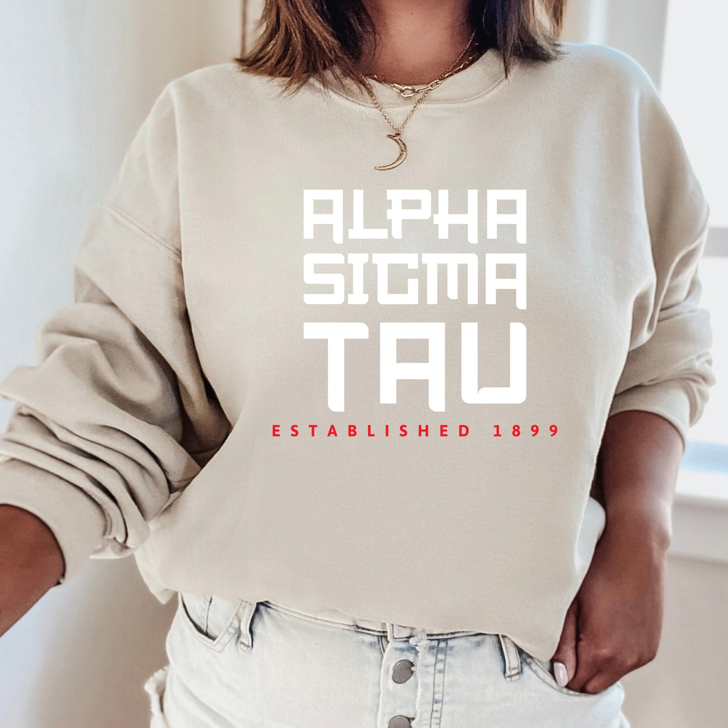 a woman wearing a sweatshirt that says alpha sigma tau established 1939