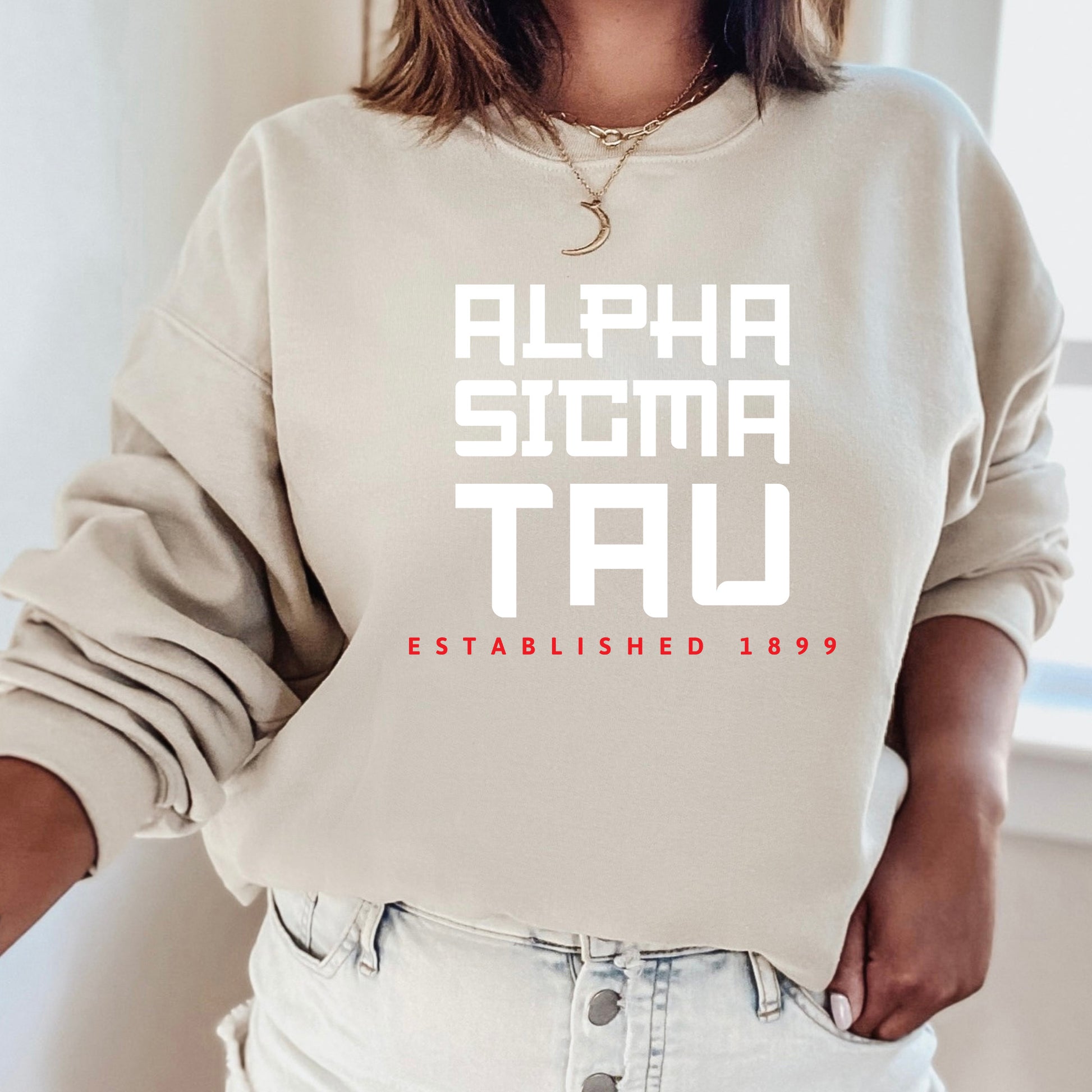 a woman wearing a sweatshirt that says alpha sigma tau established 1939