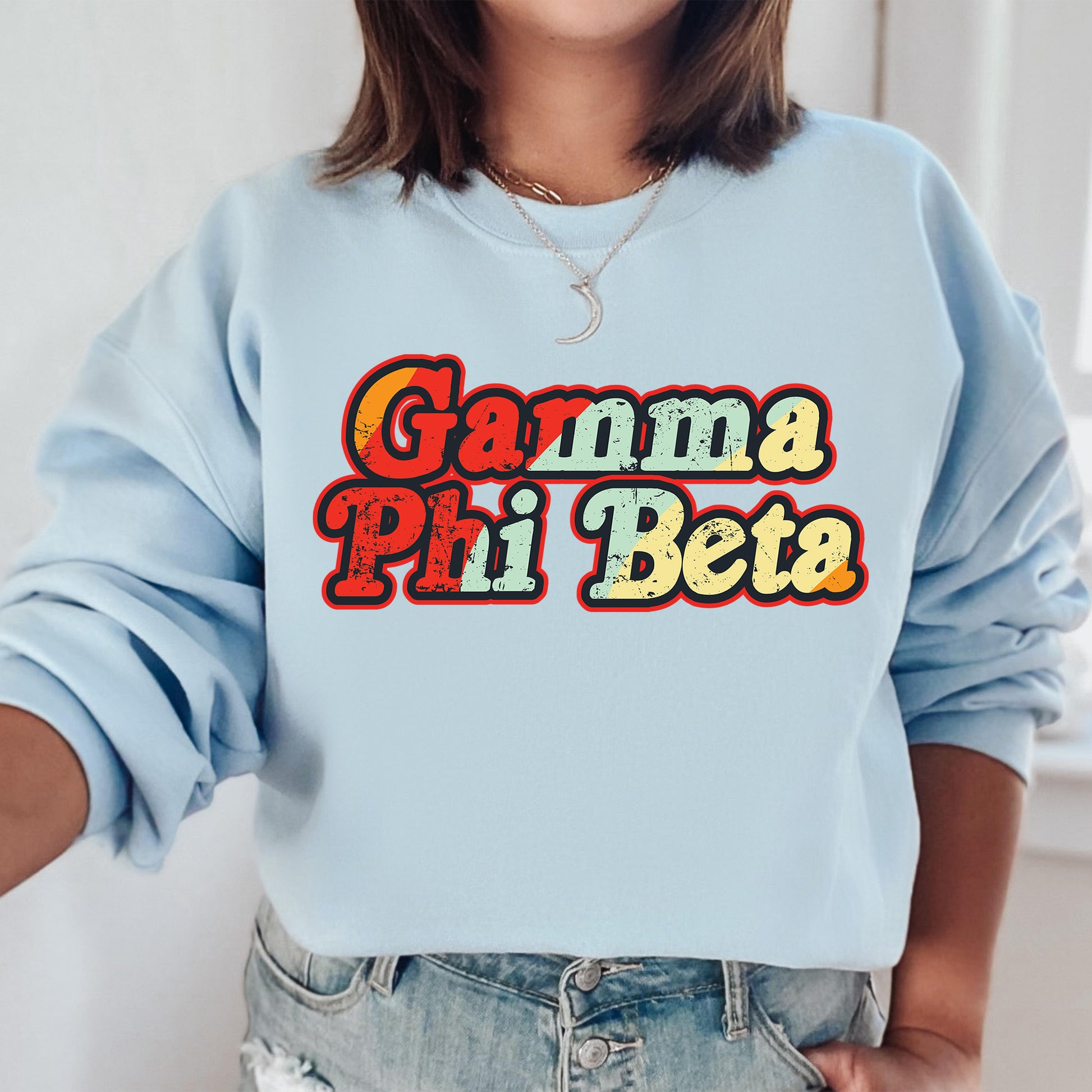 a woman wearing a light blue sweatshirt with the words garma pili beta