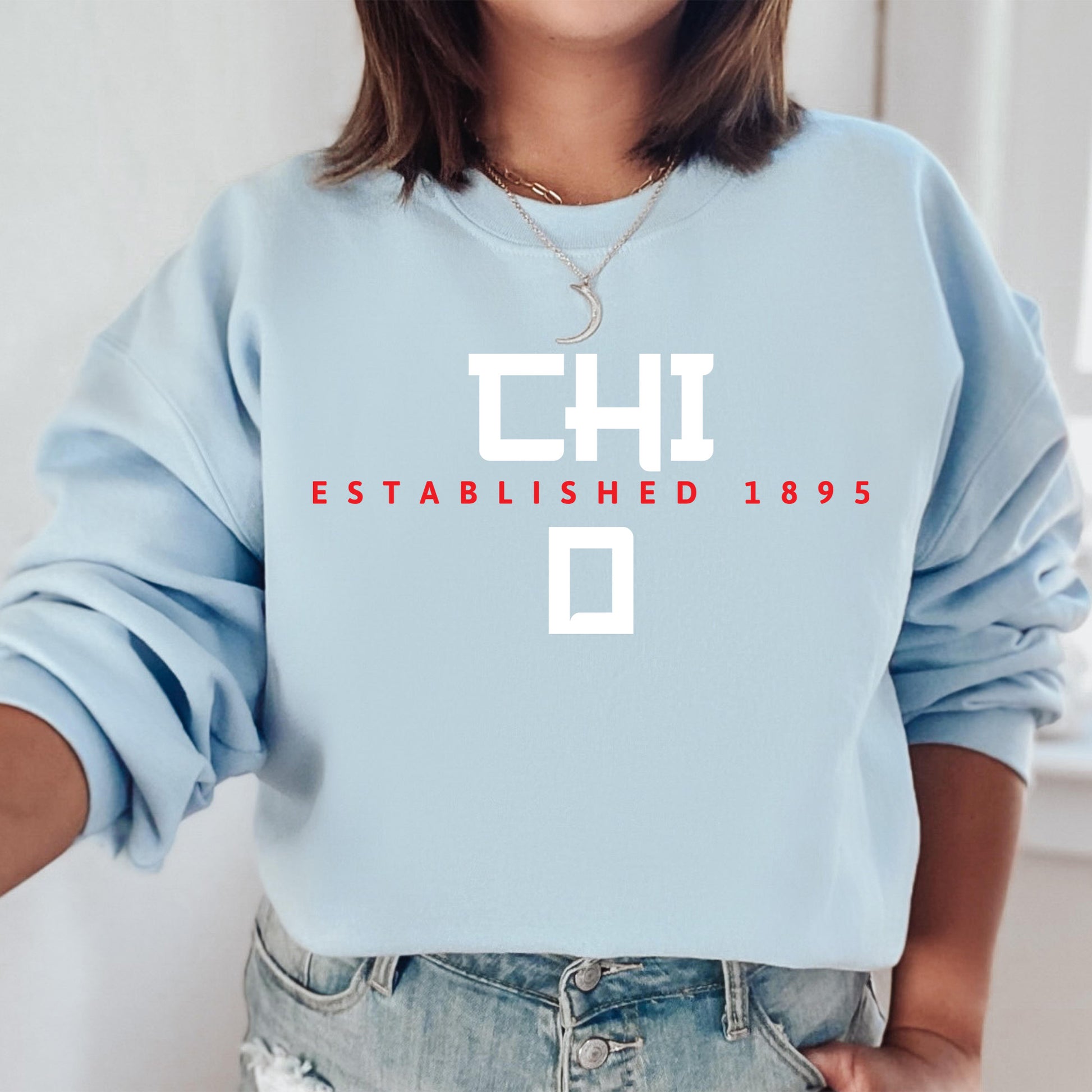 a woman wearing a blue sweatshirt with a cross on it