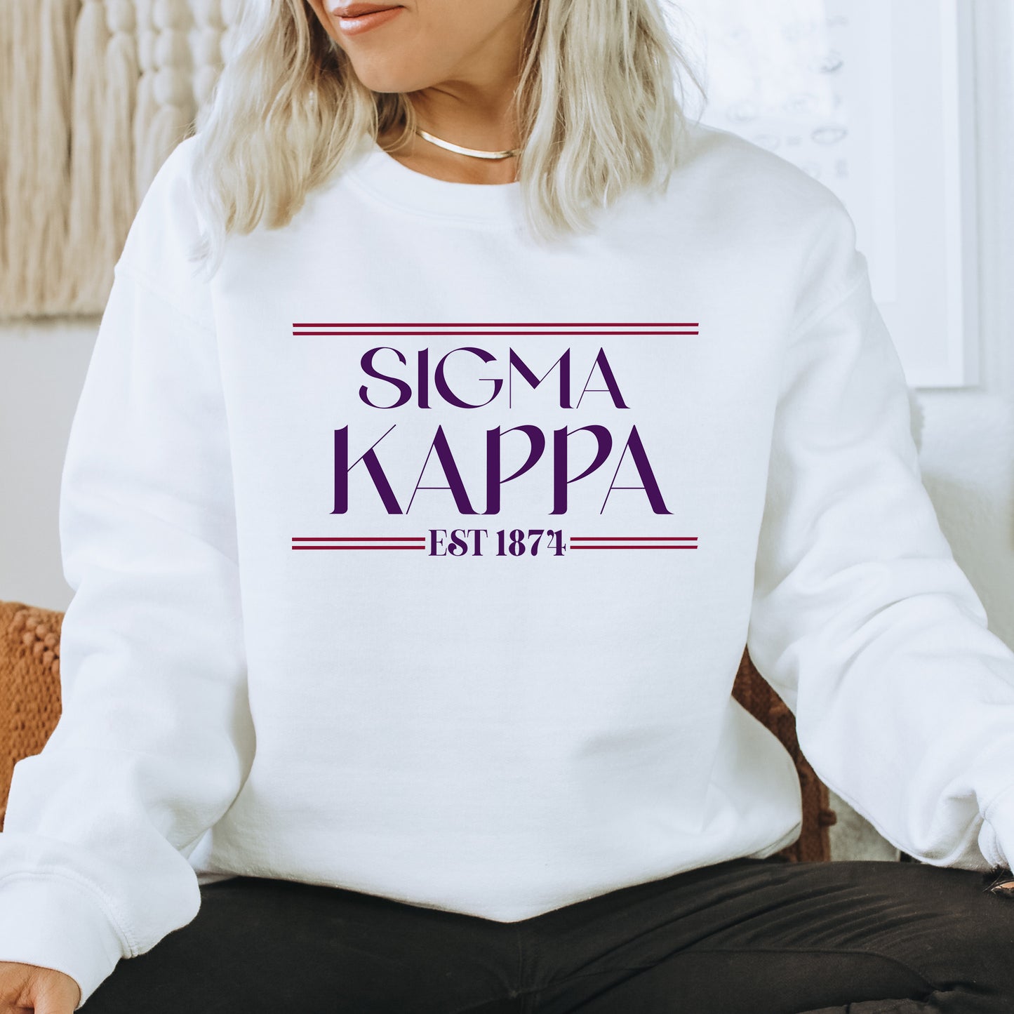 a woman sitting on a chair wearing a white sweatshirt