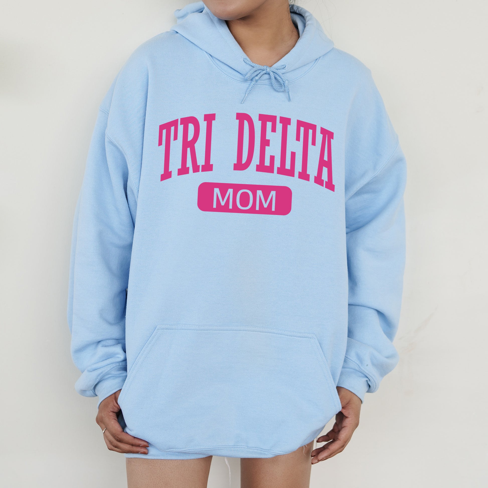 a woman wearing a blue sweatshirt with the word tri delta on it