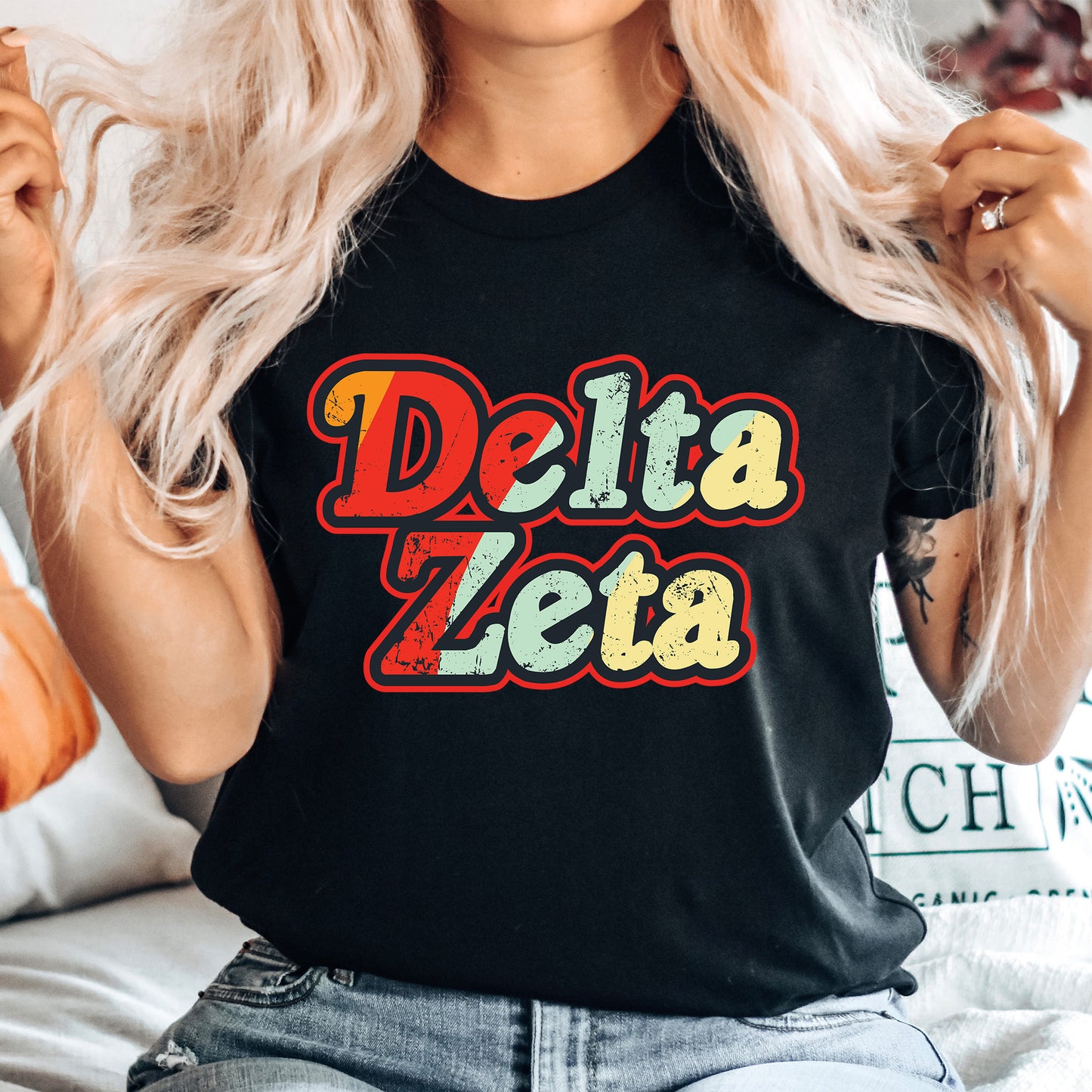 a woman with blonde hair wearing a black delta zeia t - shirt