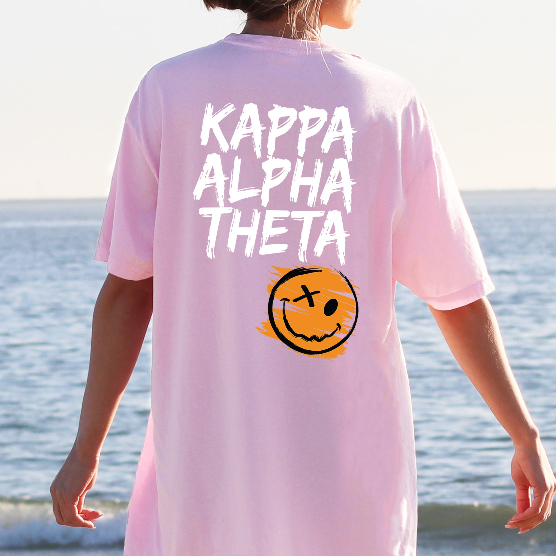 a person wearing a pink shirt with a smiley face on it
