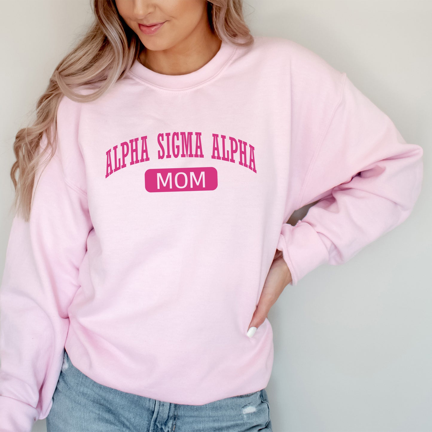 a woman wearing a pink sweatshirt with a pink mom on it