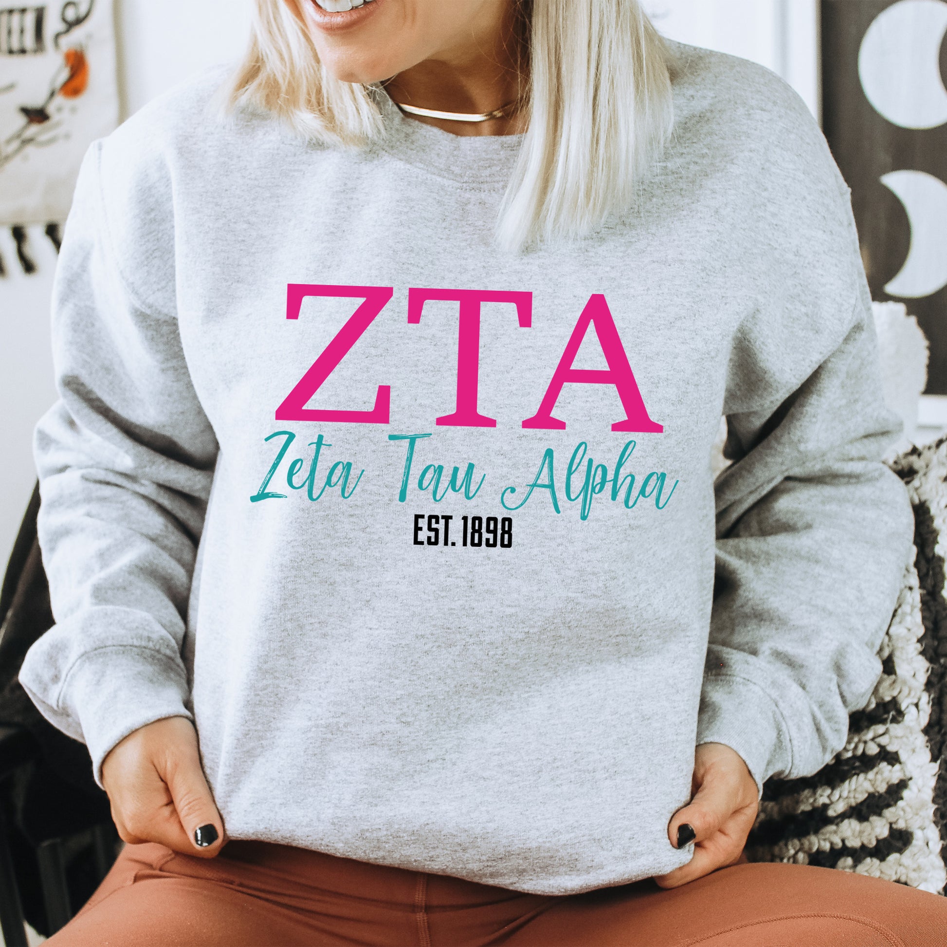 a woman sitting on a chair wearing a sweatshirt