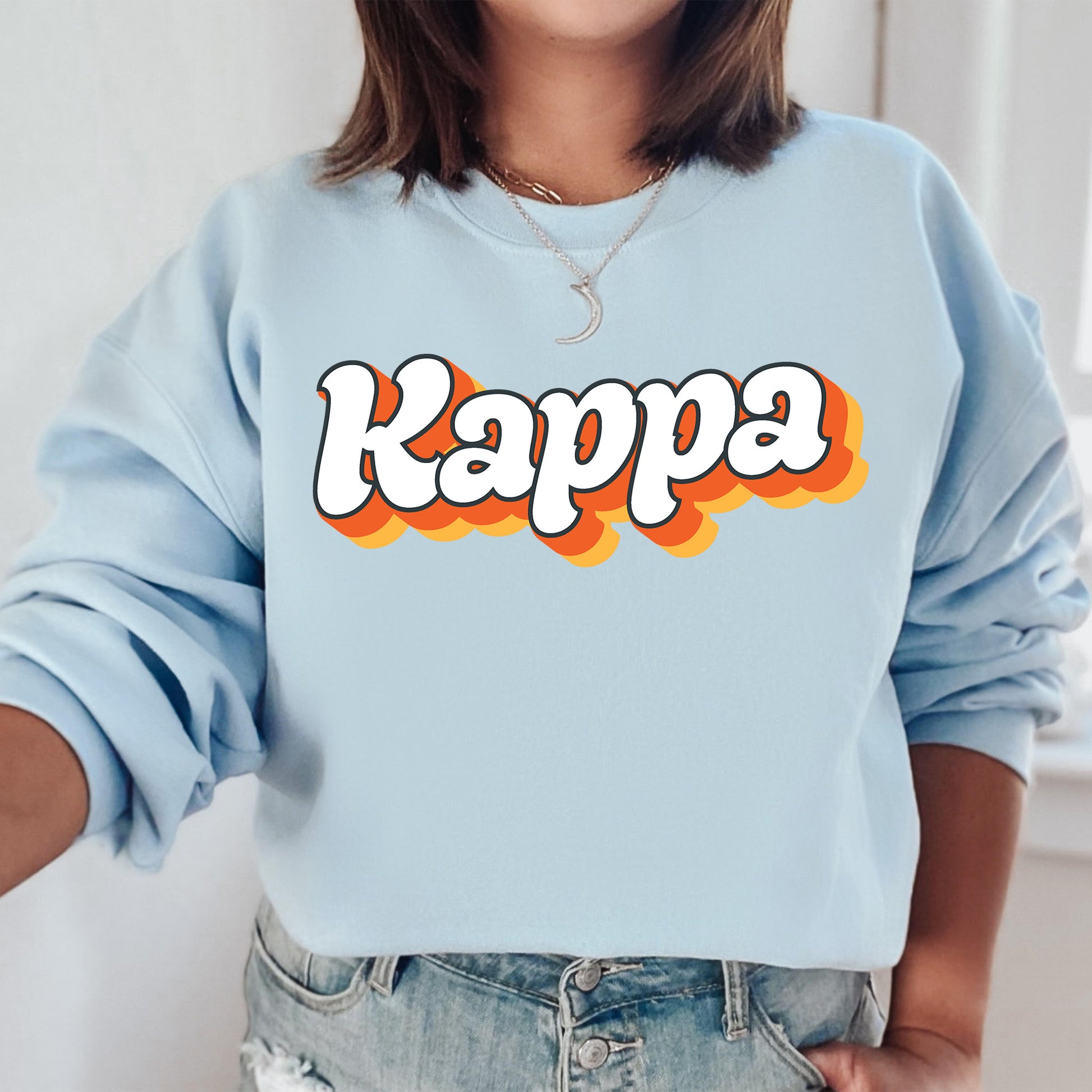 a woman wearing a blue sweatshirt with the word kappa printed on it