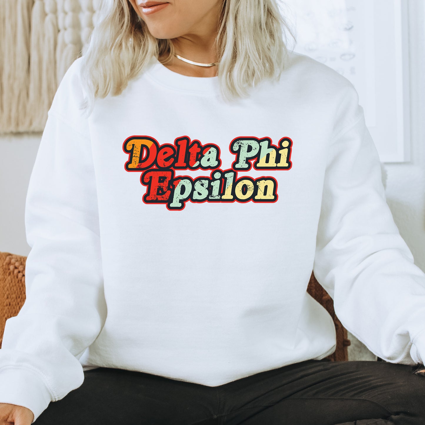 a woman sitting on a chair wearing a white sweatshirt