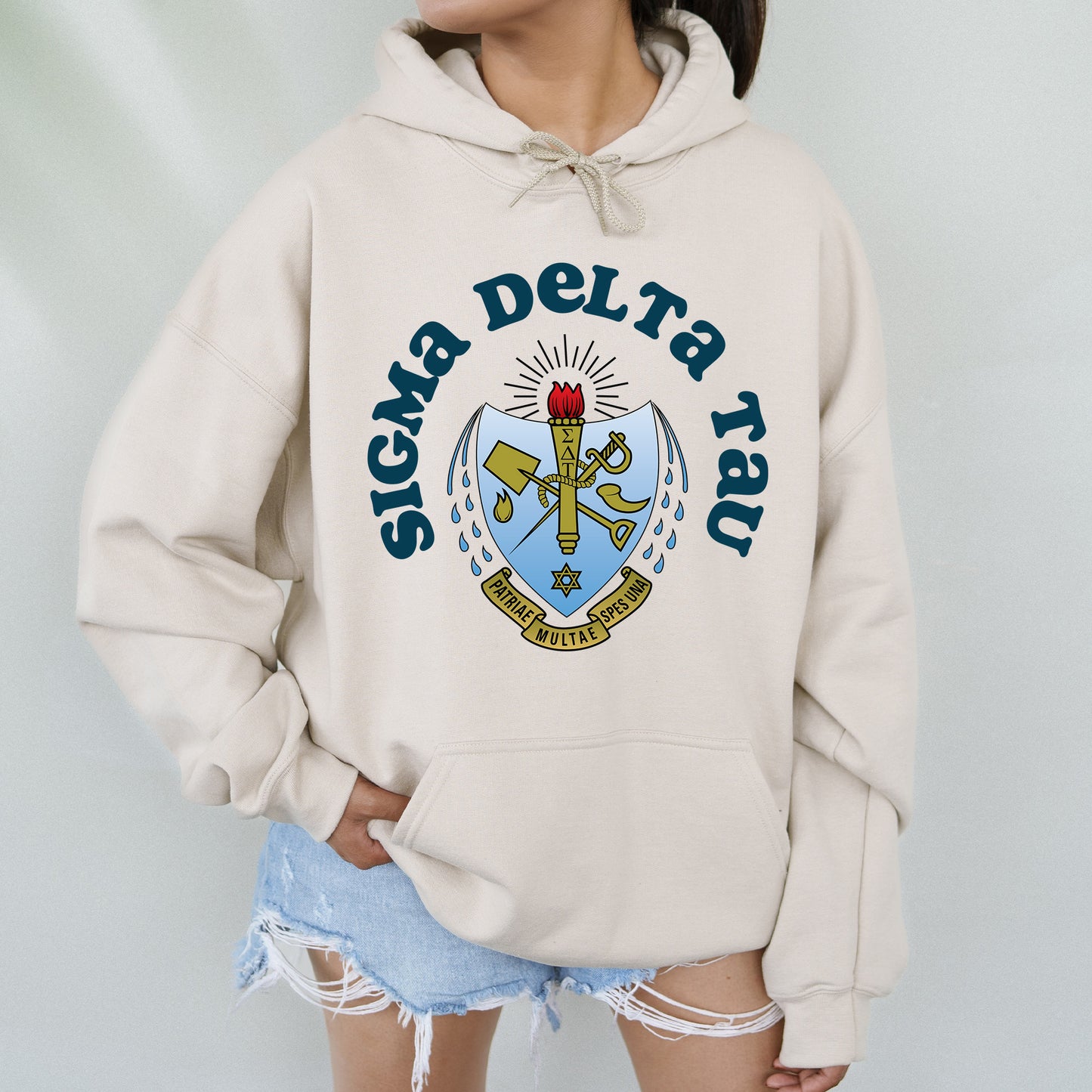 a woman wearing a white hoodie with a coat of arms on it