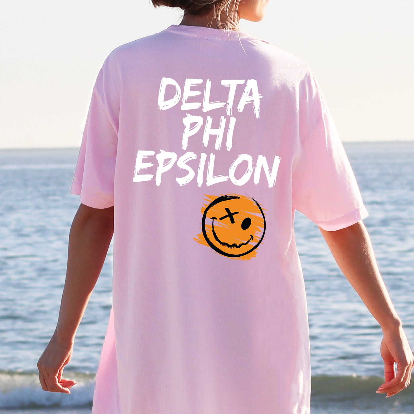 a person wearing a pink shirt with a smiley face on it