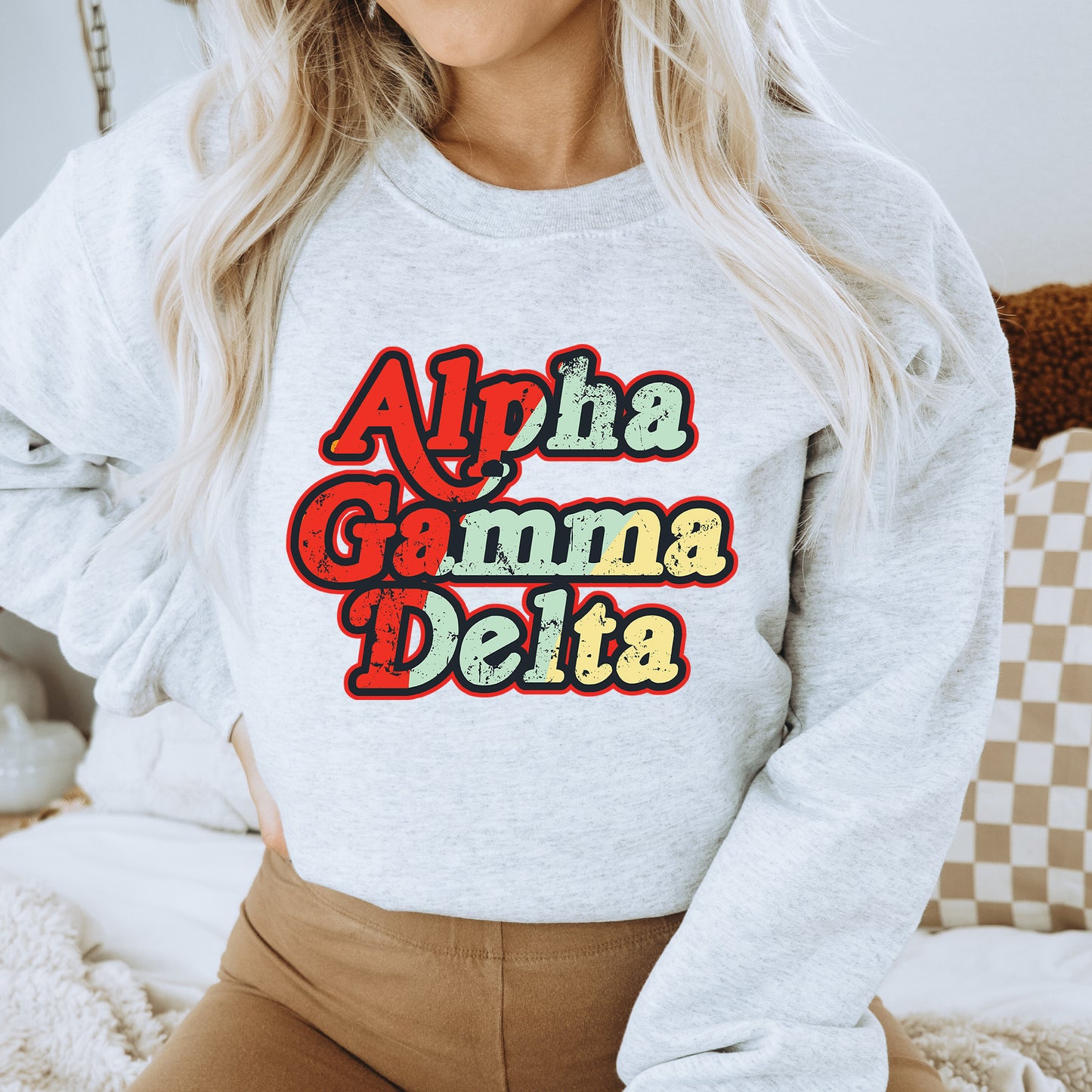 a woman wearing a white sweatshirt with the words aloh gamma delta on it