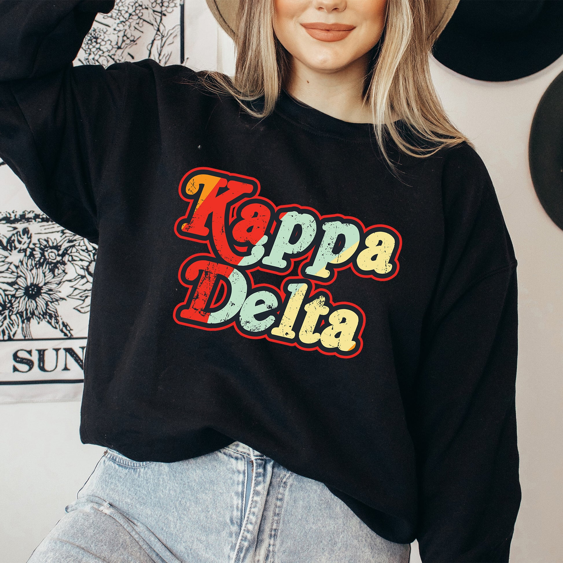 a woman wearing a black sweatshirt with the words kappa delta on it