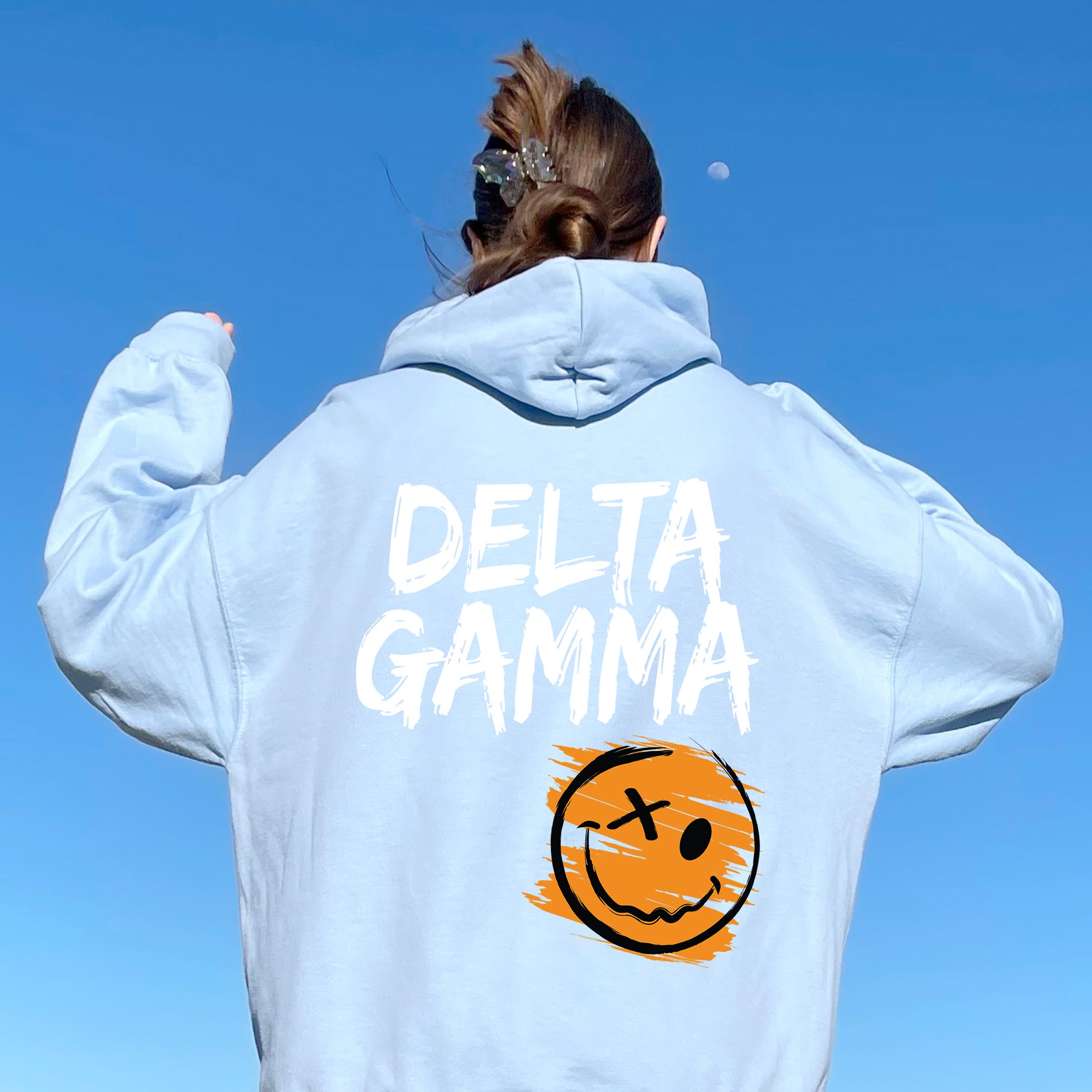 a woman wearing a sweatshirt with a smiley face on it