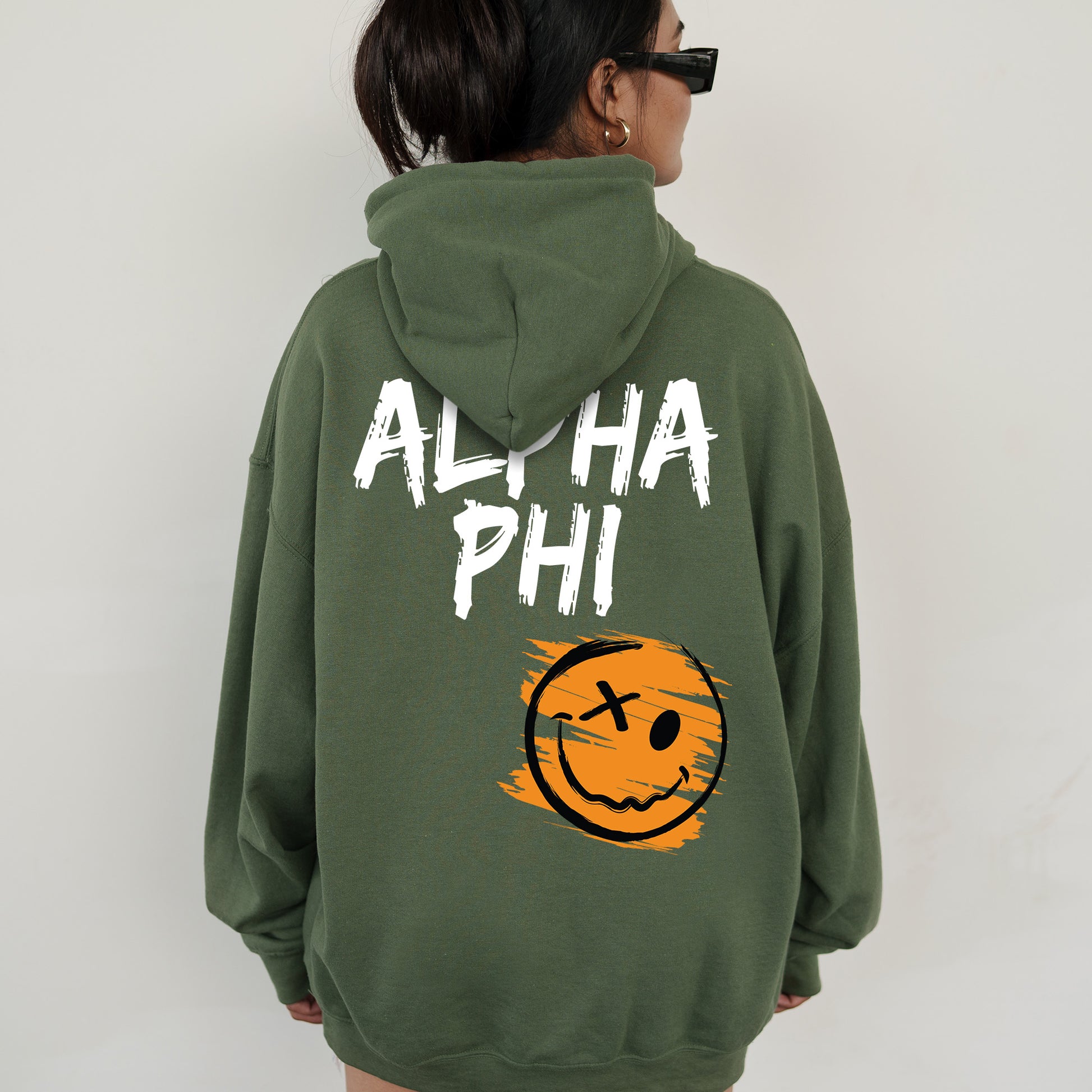 a woman wearing a green hoodie with a smiley face on it