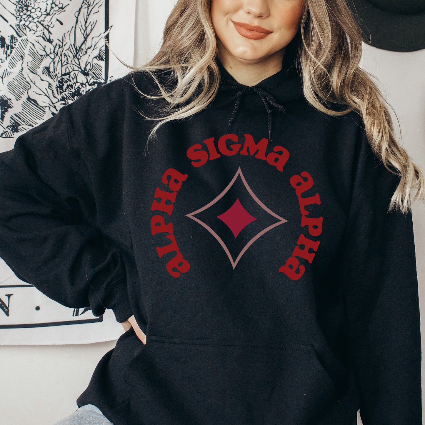 a woman wearing a black hoodie with a red design on it