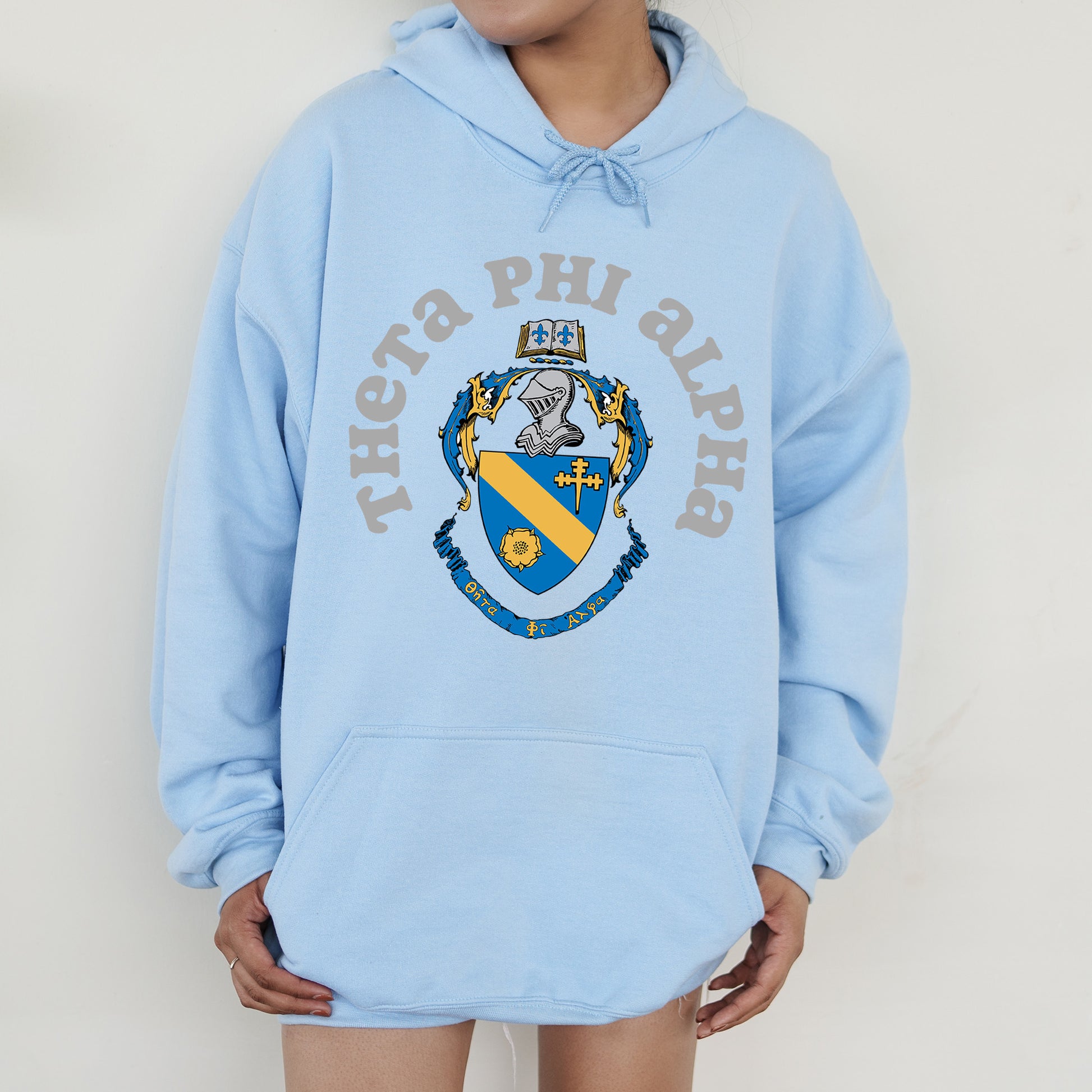 a person wearing a blue hoodie with a coat of arms on it