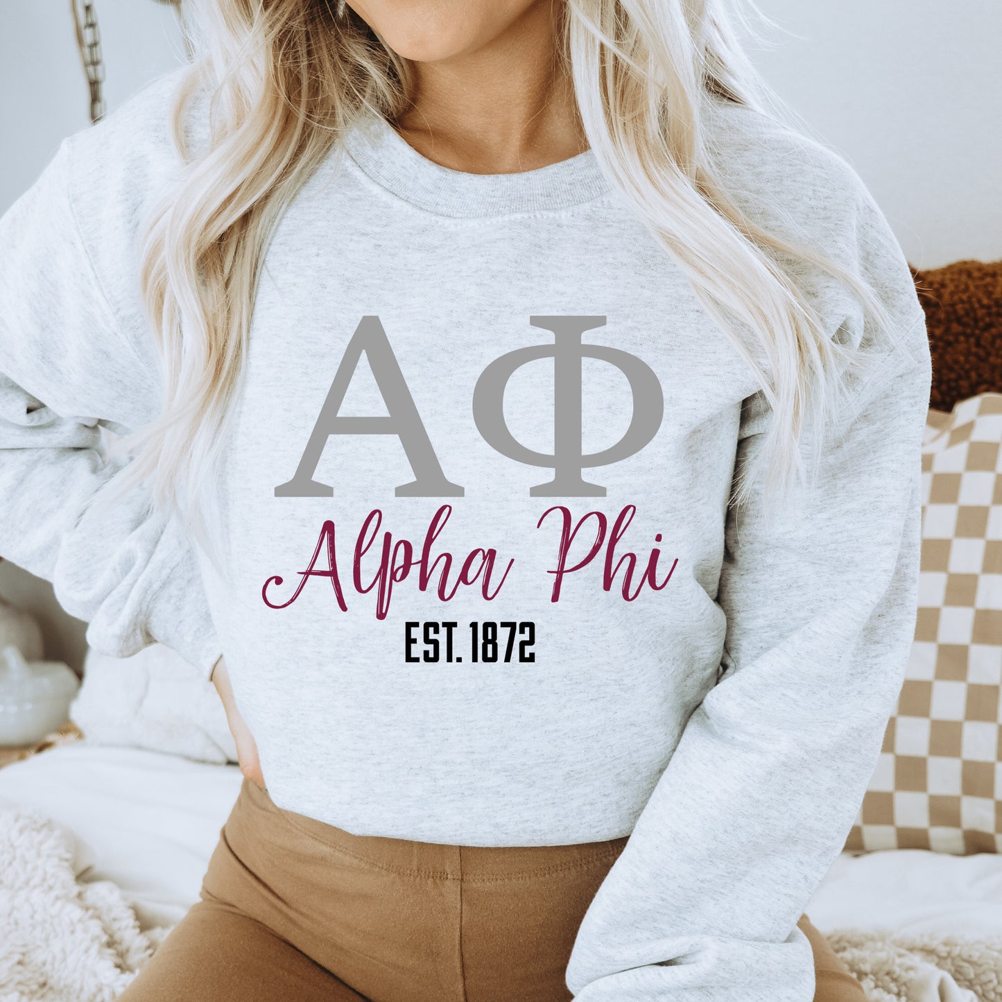 a woman wearing a sweatshirt with the letters phi phi on it