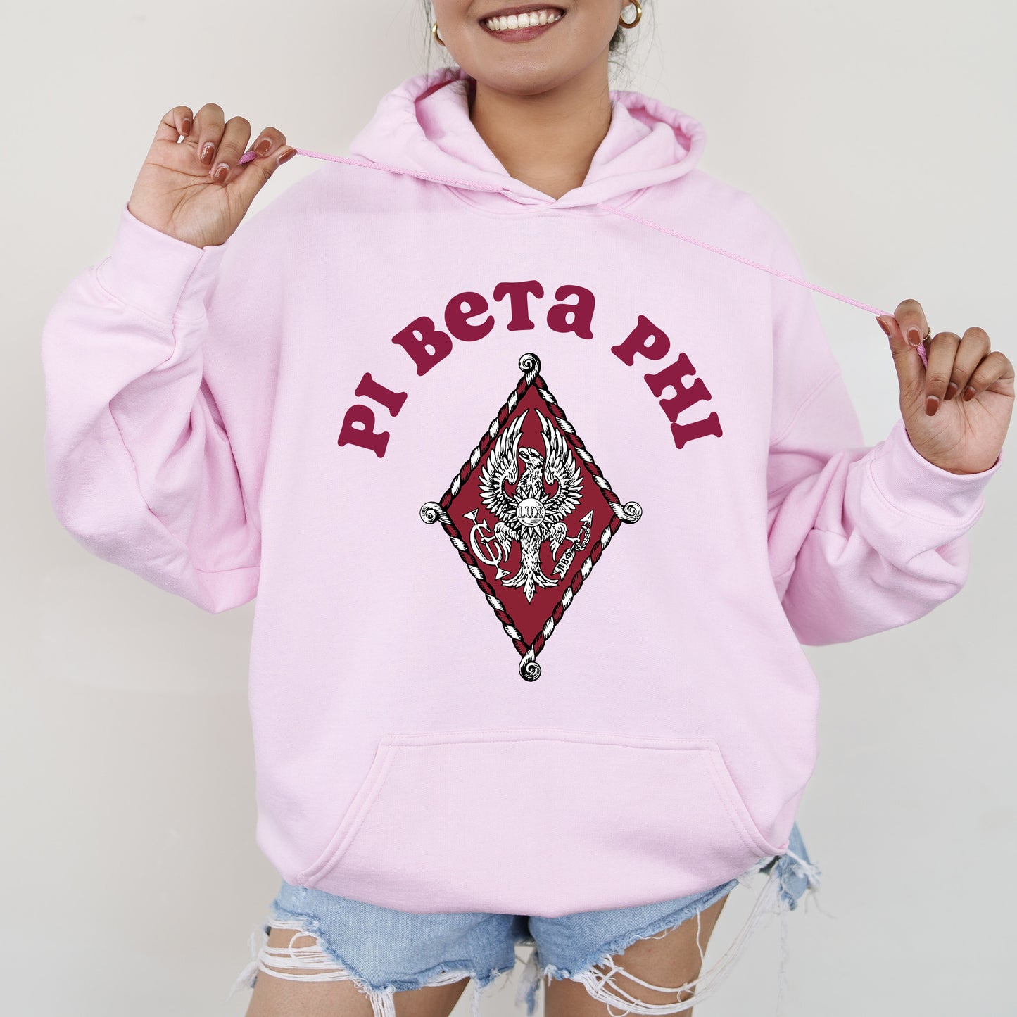 a woman wearing a pink hoodie with the words pat pat pat on it
