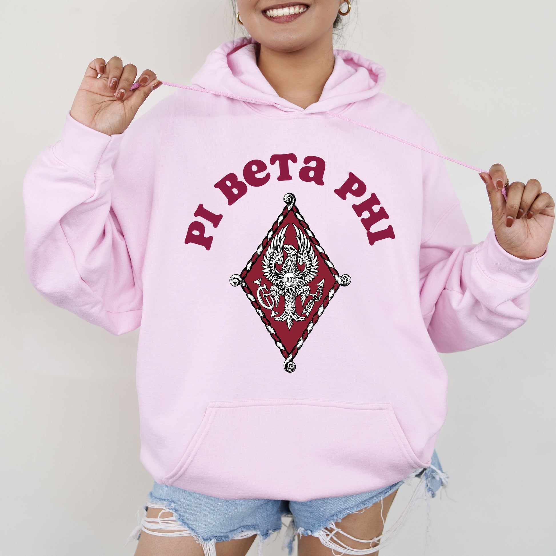 a woman wearing a pink hoodie with the words pat pat pat on it