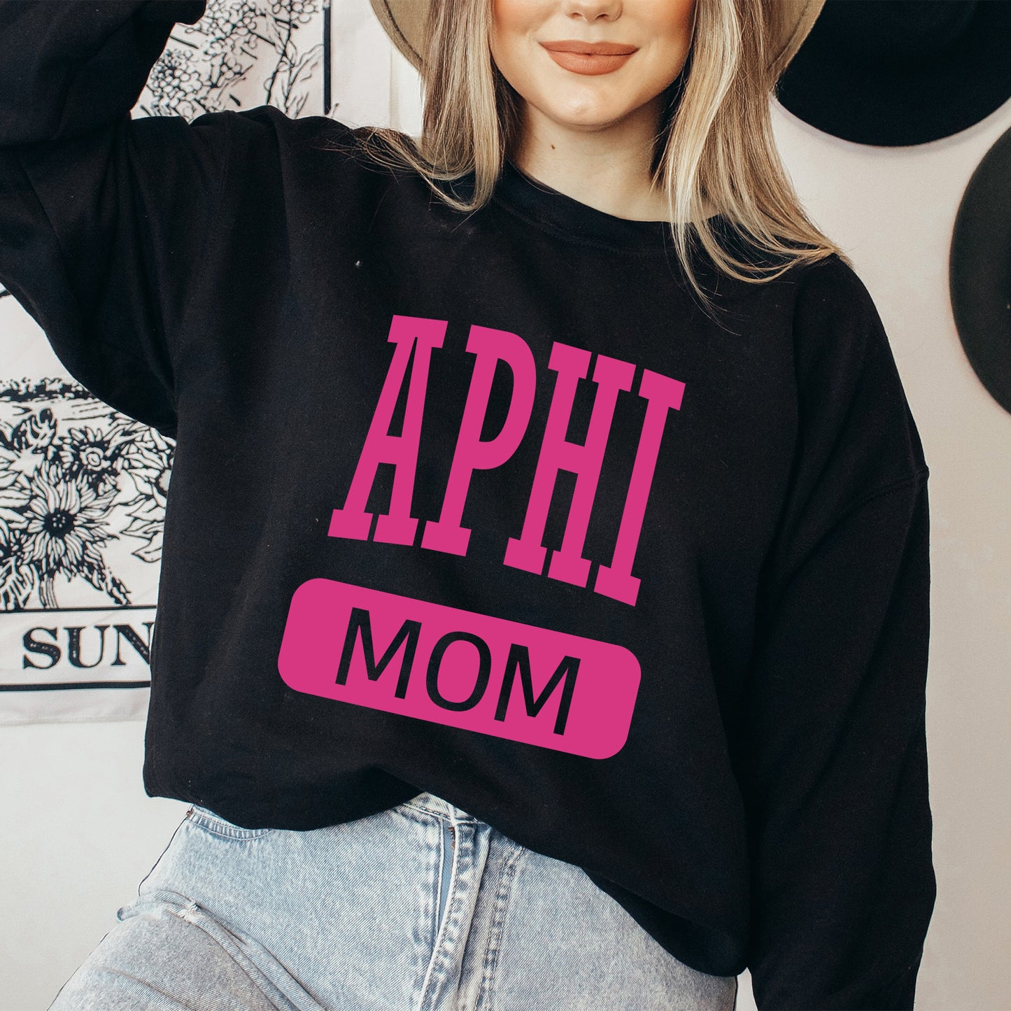 a woman wearing a hat and a sweatshirt with the words aphi mom on it