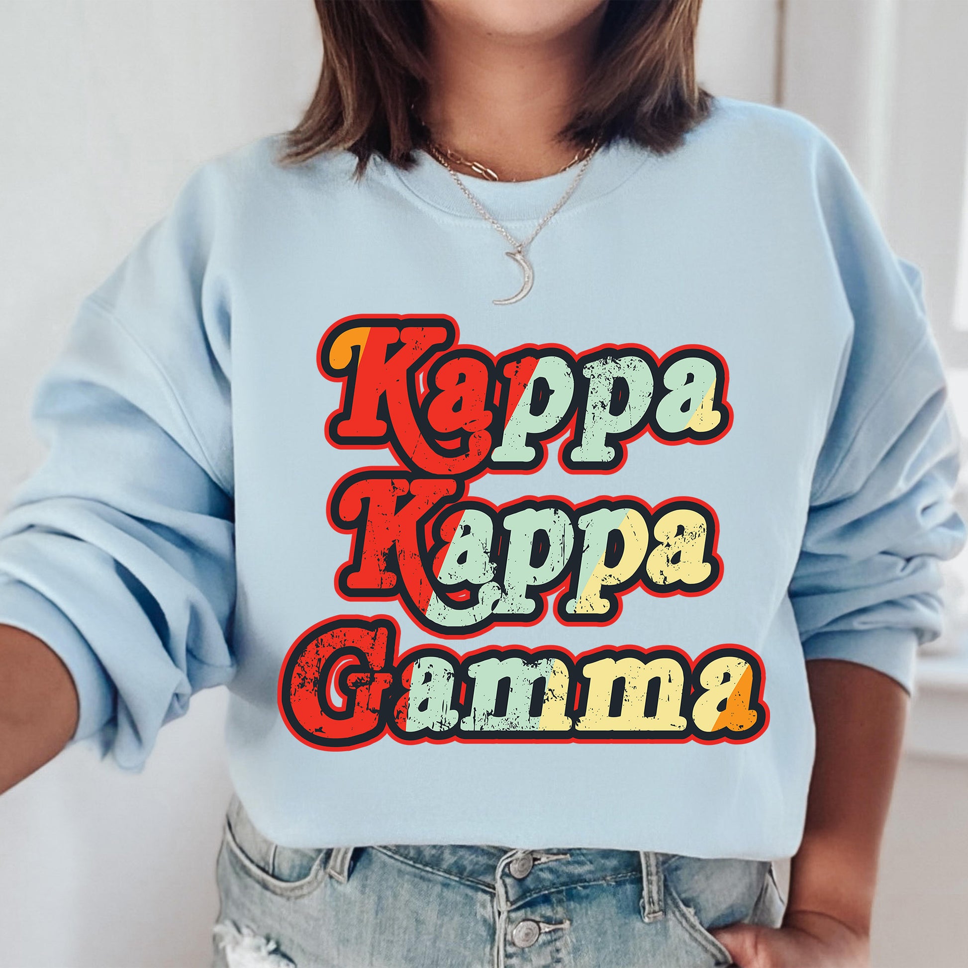 a woman wearing a blue sweatshirt with the words kappa kappa ka