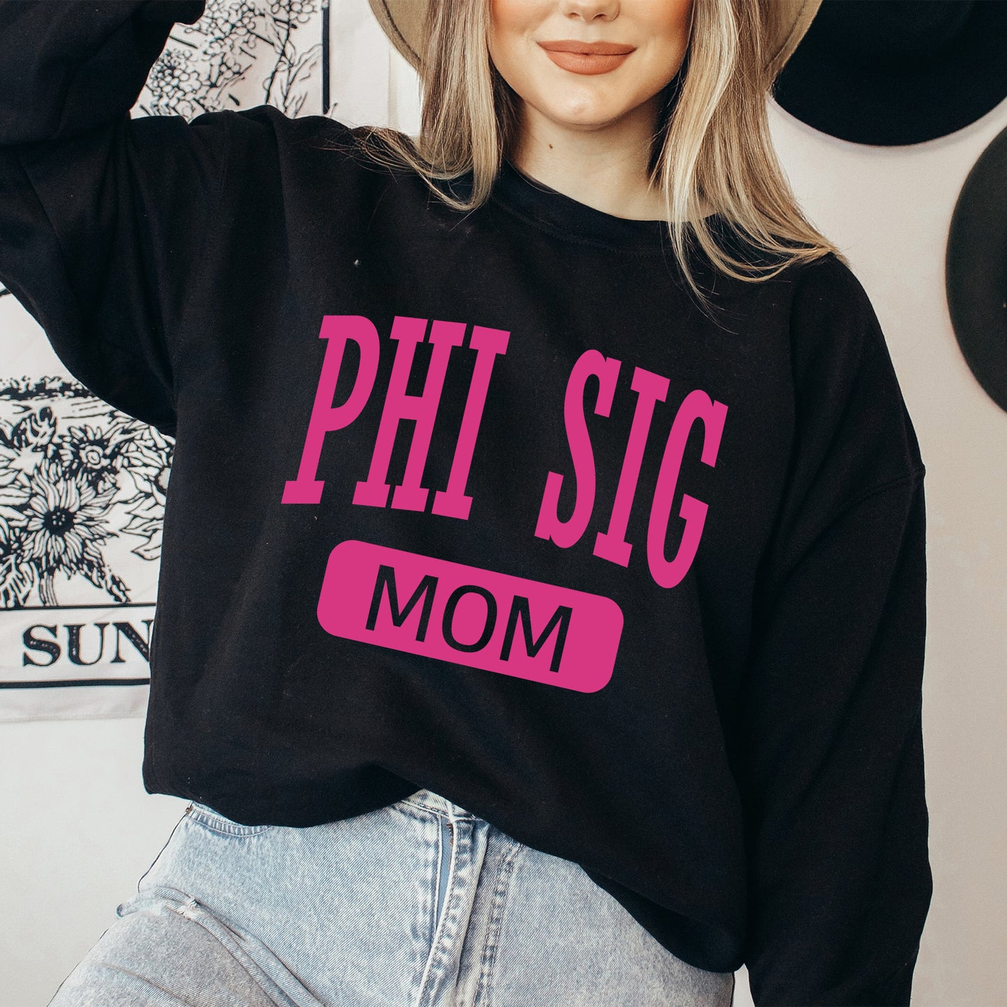a woman wearing a black sweatshirt with pink letters on it