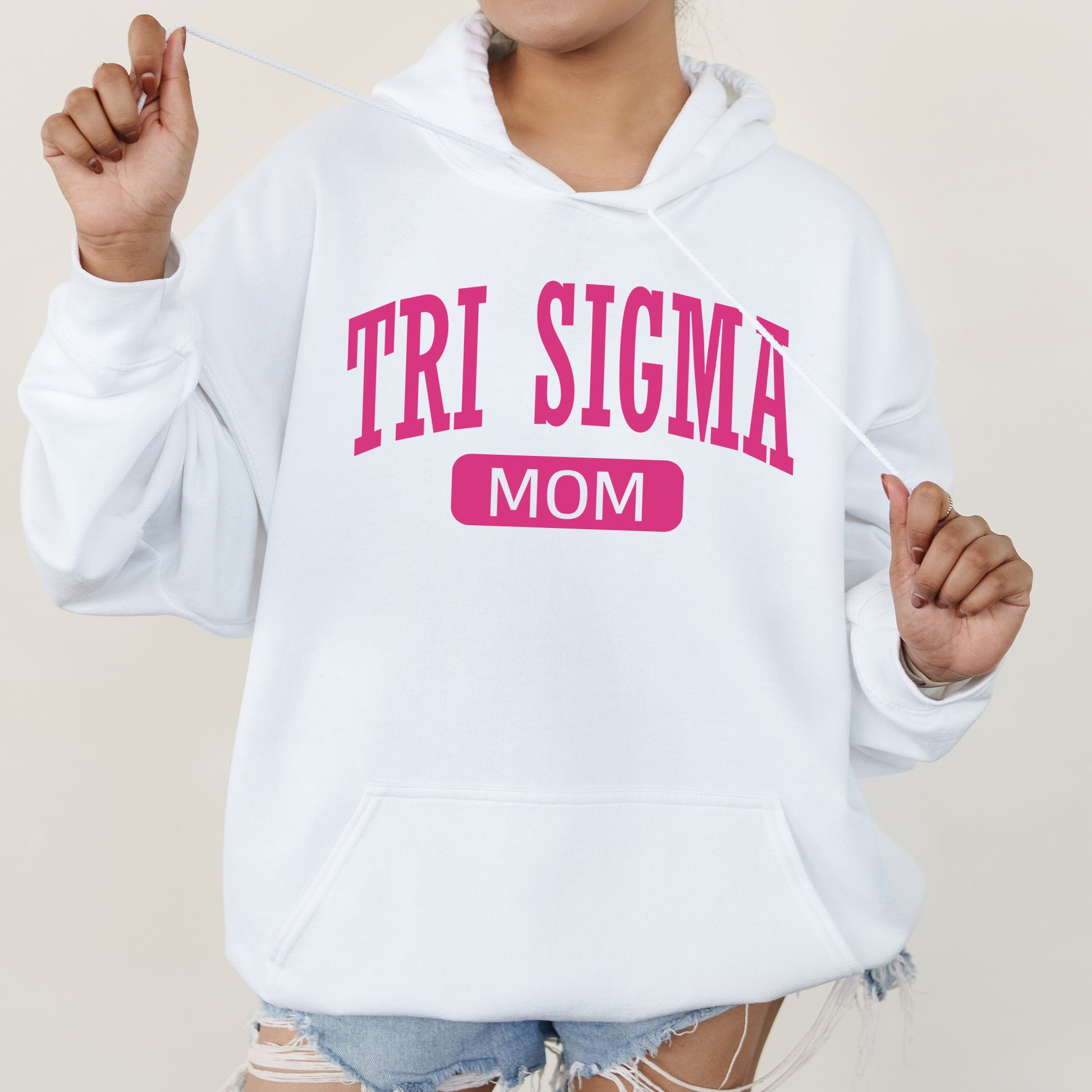 a woman wearing a white hoodie that says tri sigma mom