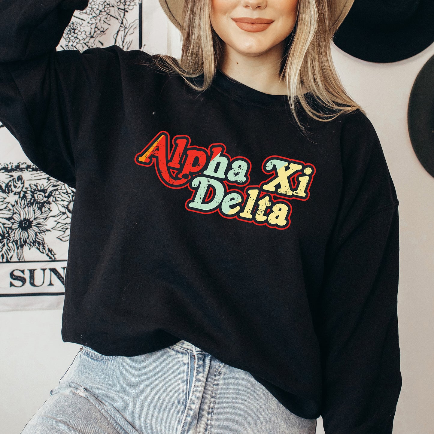 a woman wearing a black sweatshirt with the words apha xi delta on it
