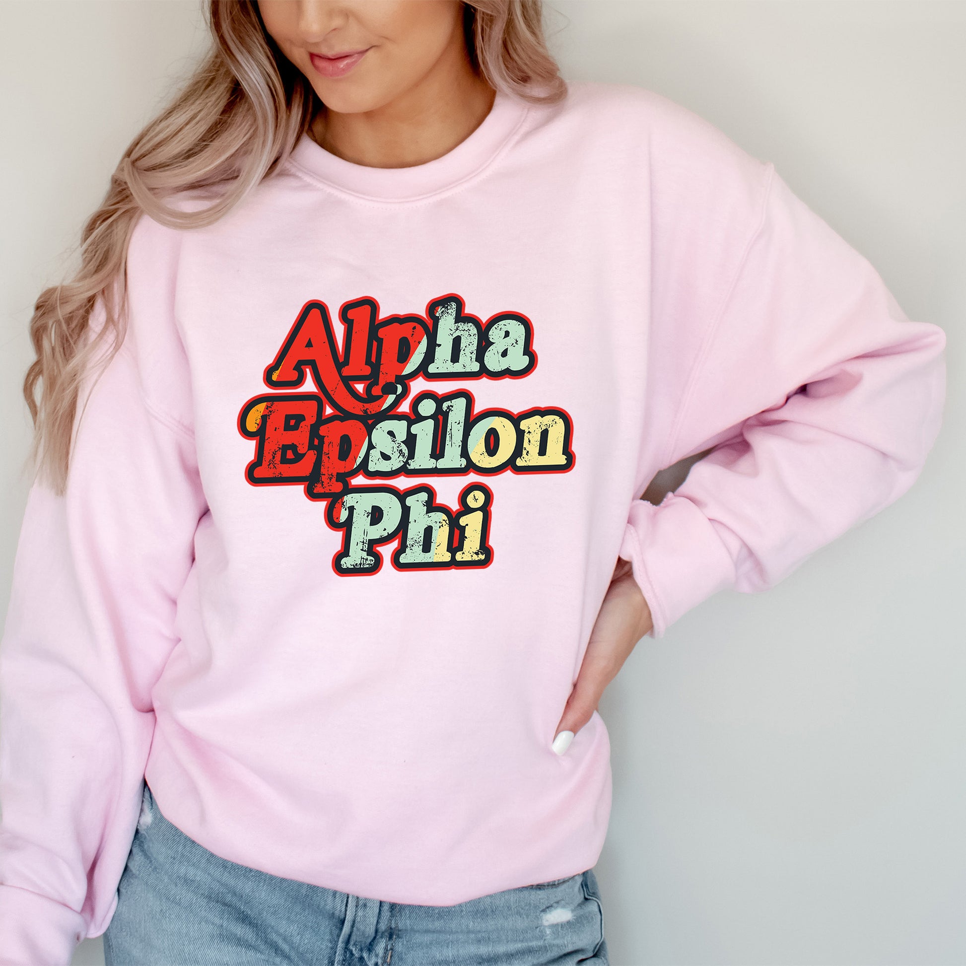 a woman wearing a pink sweatshirt with the words aloha epsilon phi