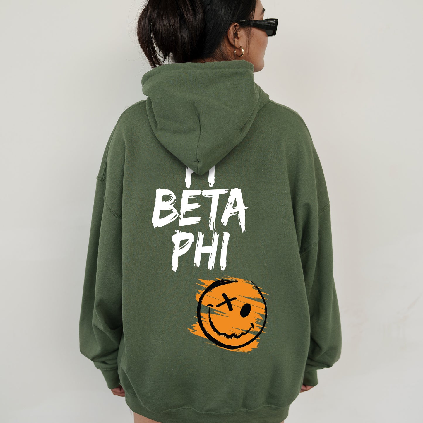 a woman wearing a green hoodie with a smiley face on it