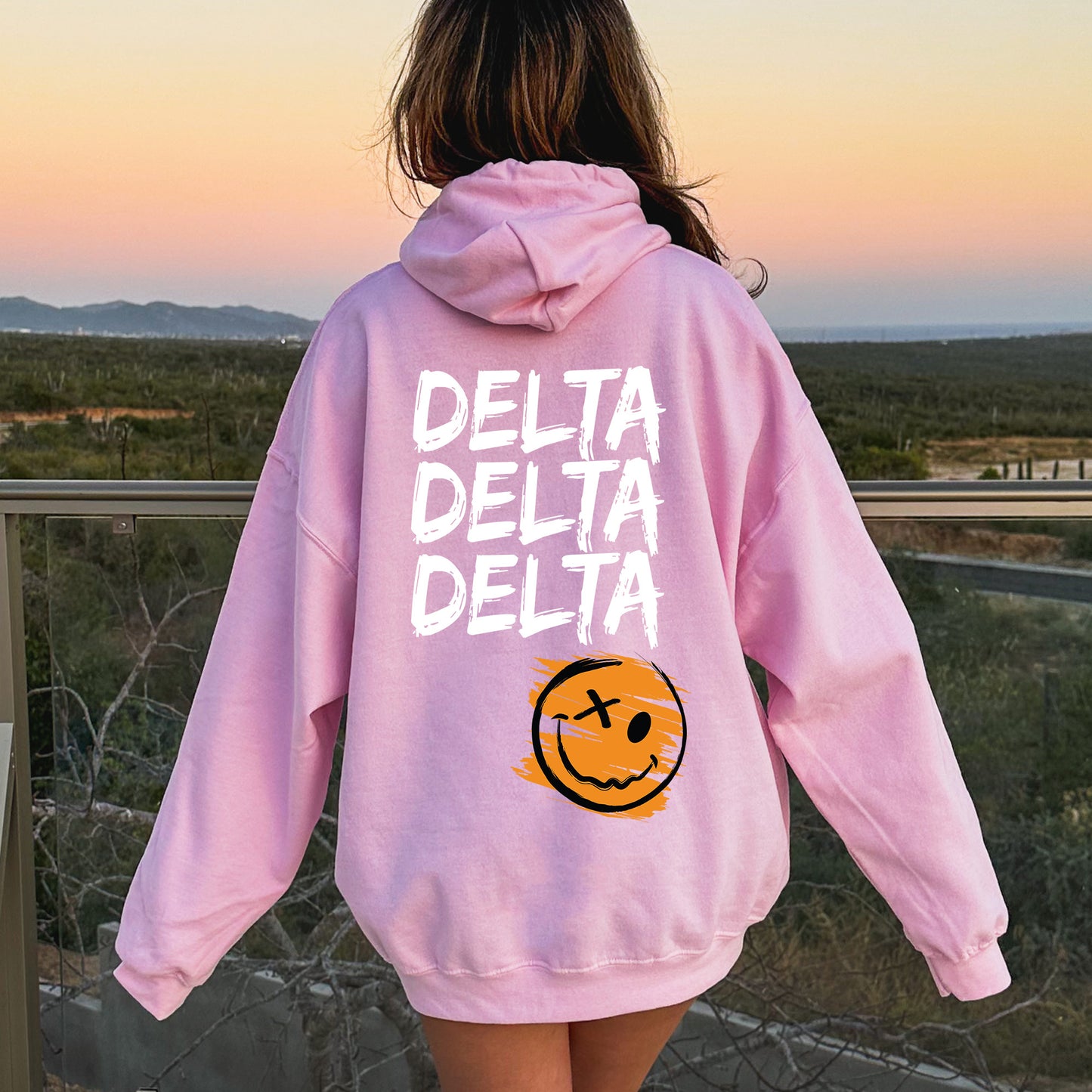 a girl in a pink hoodie that says delta delta