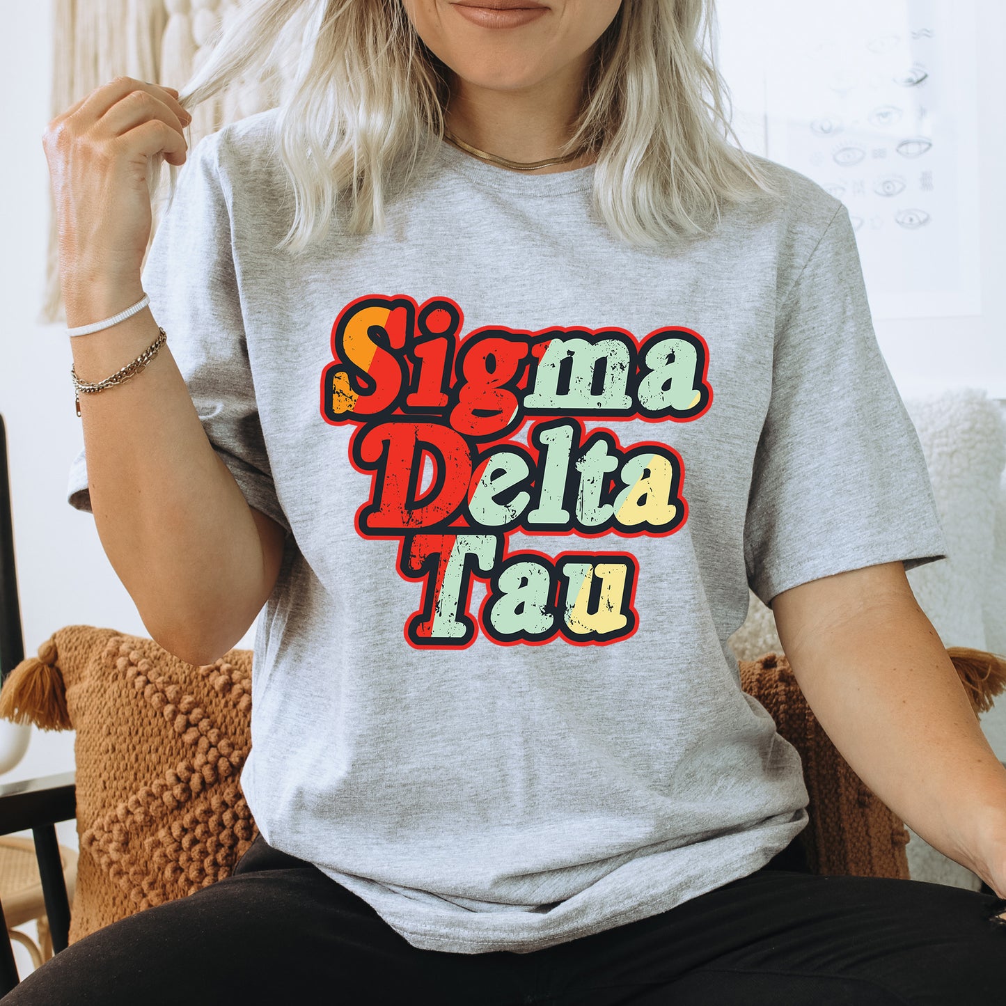 a woman sitting on a chair wearing a t - shirt that says stigmaa delta