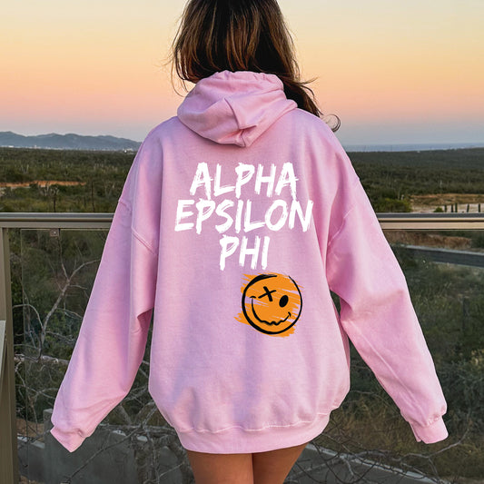 a person wearing a pink sweatshirt with a smiley face on it